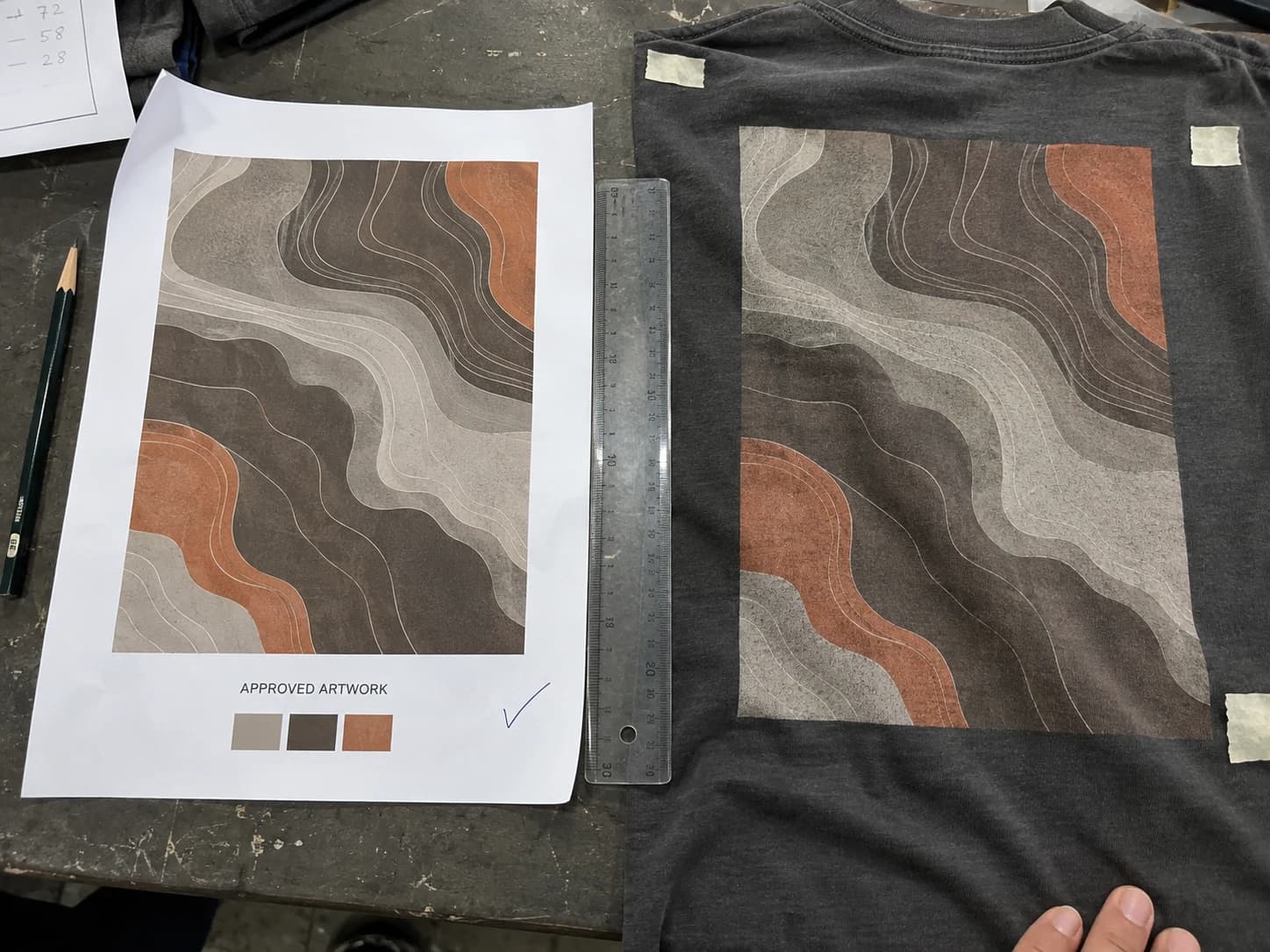 Approved garment artwork beside a physical print sample and measuring ruler