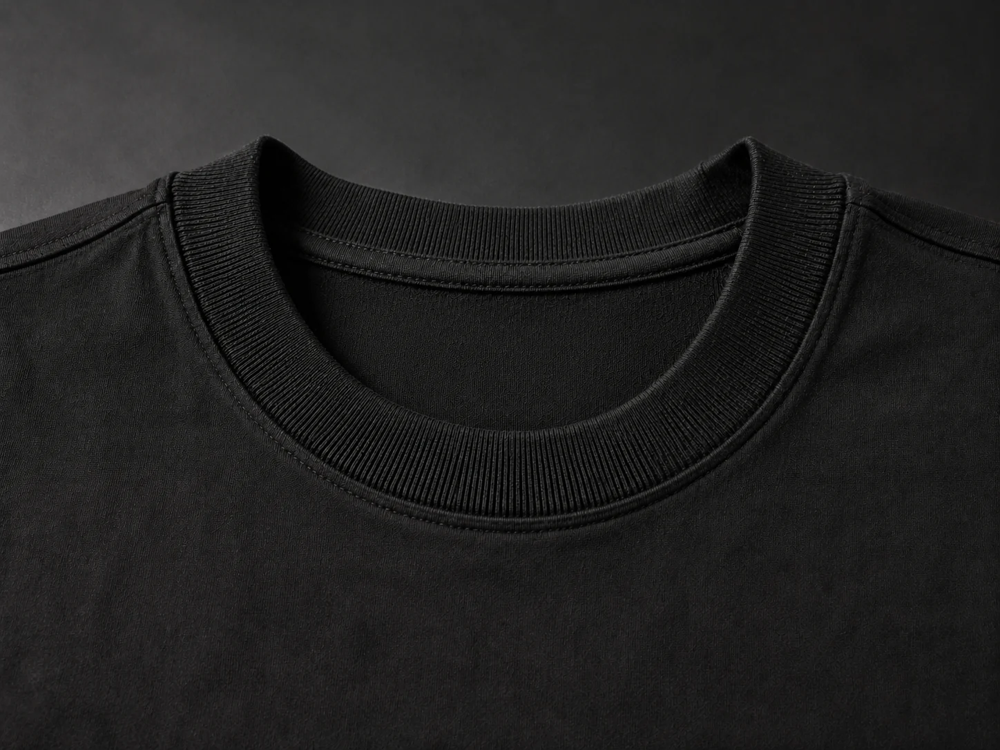 Close-up of a thick rib collar sewn to a heavyweight black T-shirt