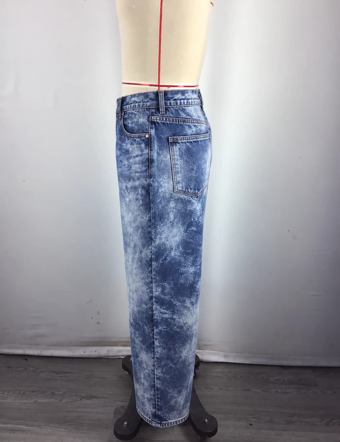 Actual acid-wash wide-leg jeans sample shown from the side on a mannequin
