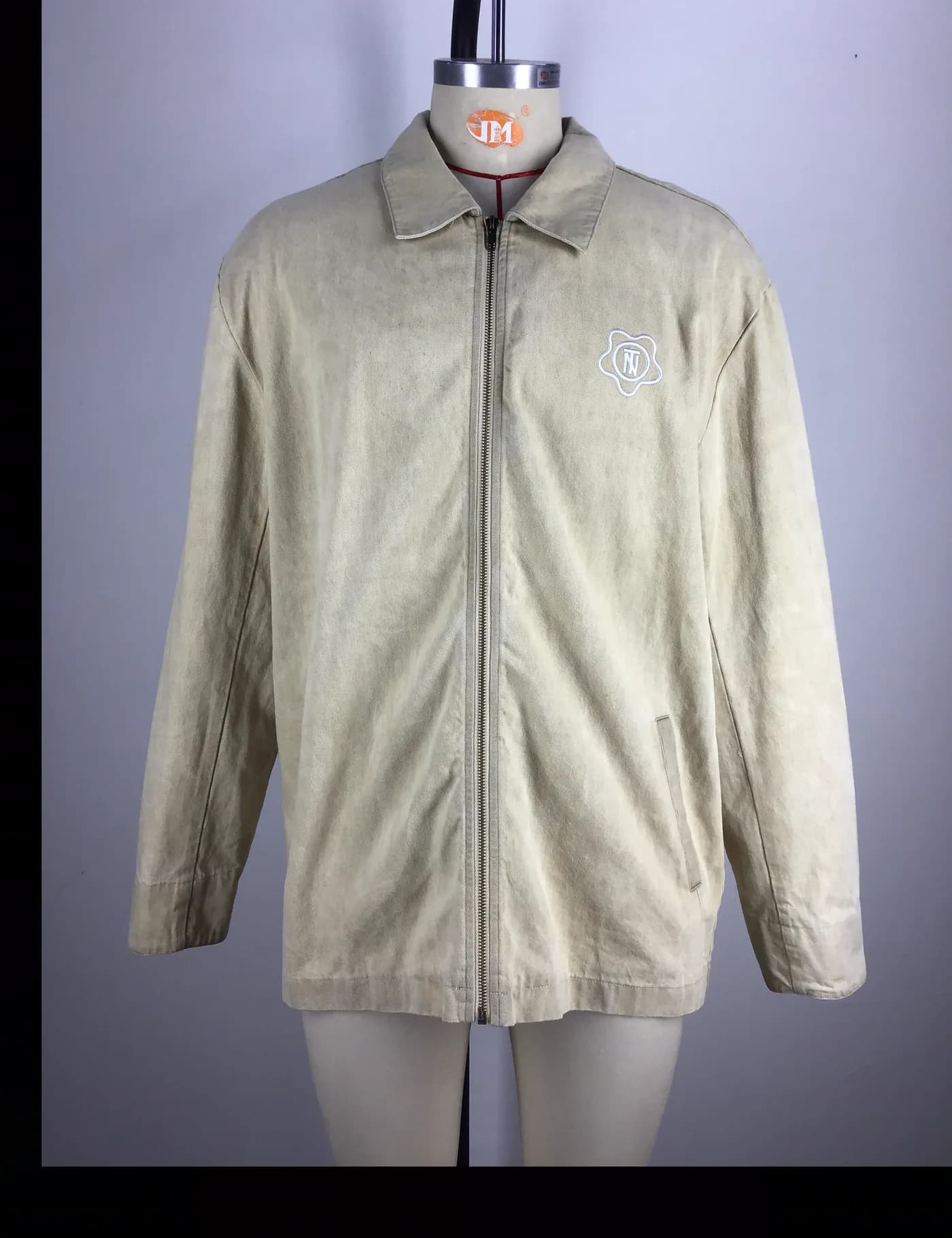 Actual beige washed zip coach jacket sample shown from the front on a mannequin
