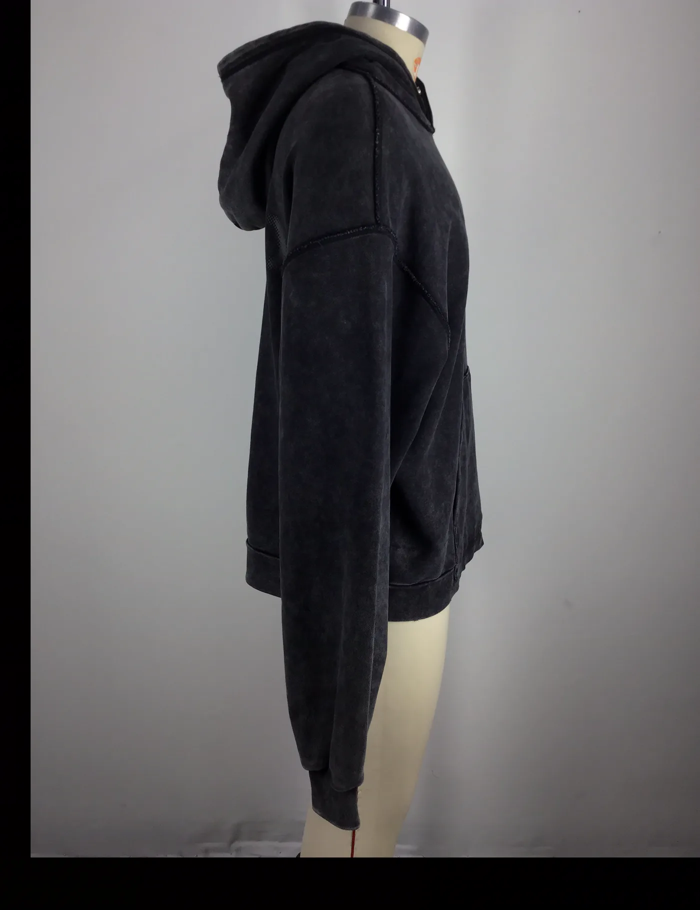 Actual black acid-wash pullover hoodie sample shown from the side on a mannequin