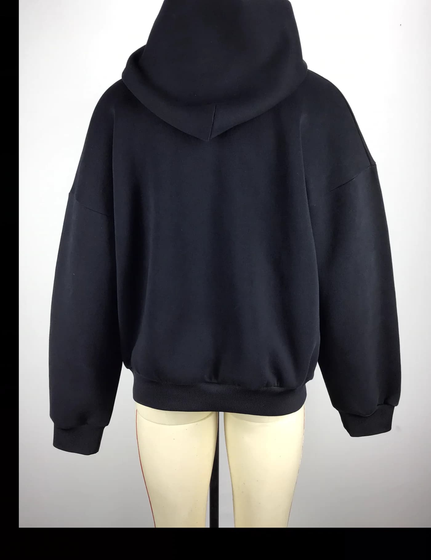 Actual black oversized pullover hoodie sample shown from the back on a mannequin