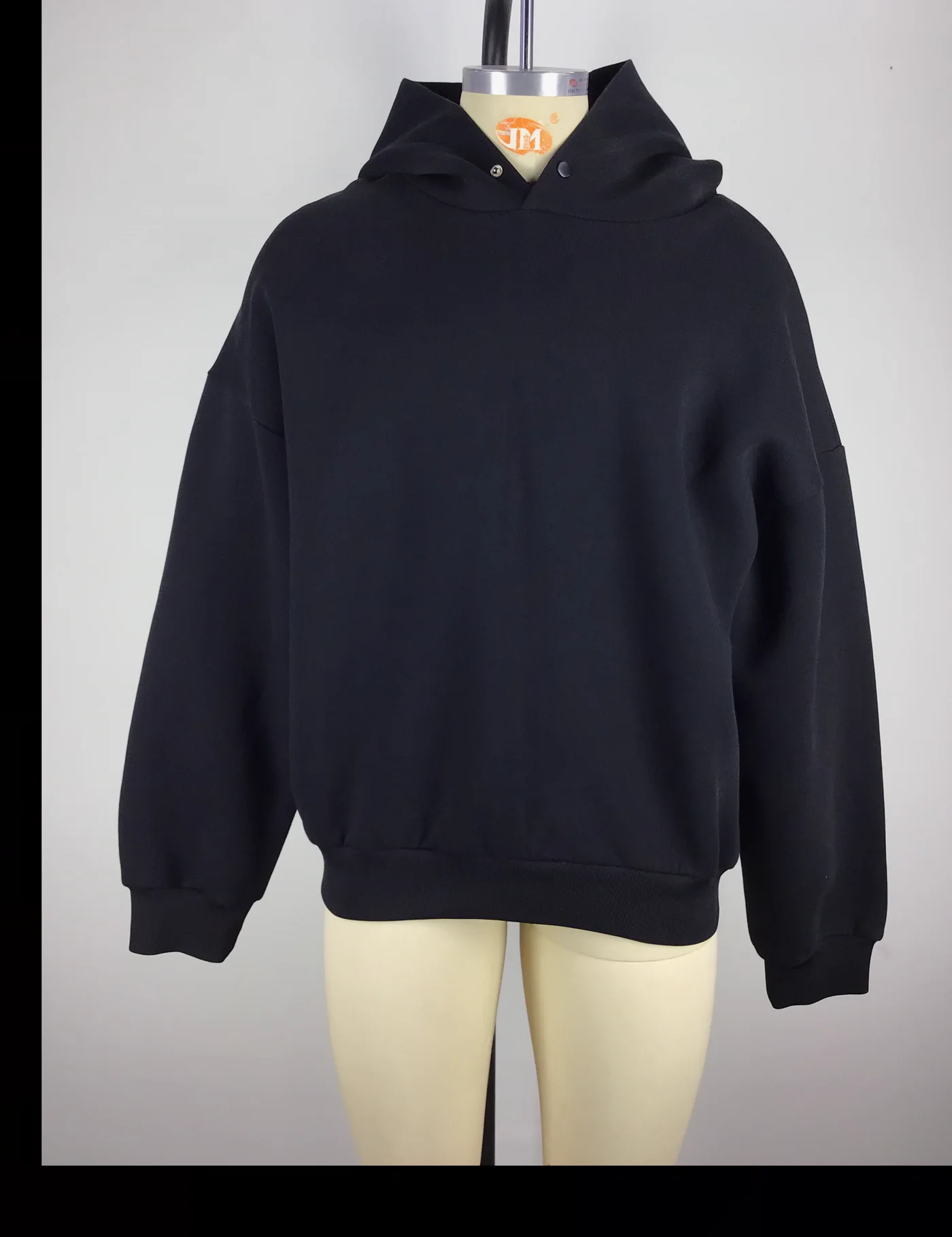 Actual black oversized pullover hoodie sample shown from the front on a mannequin