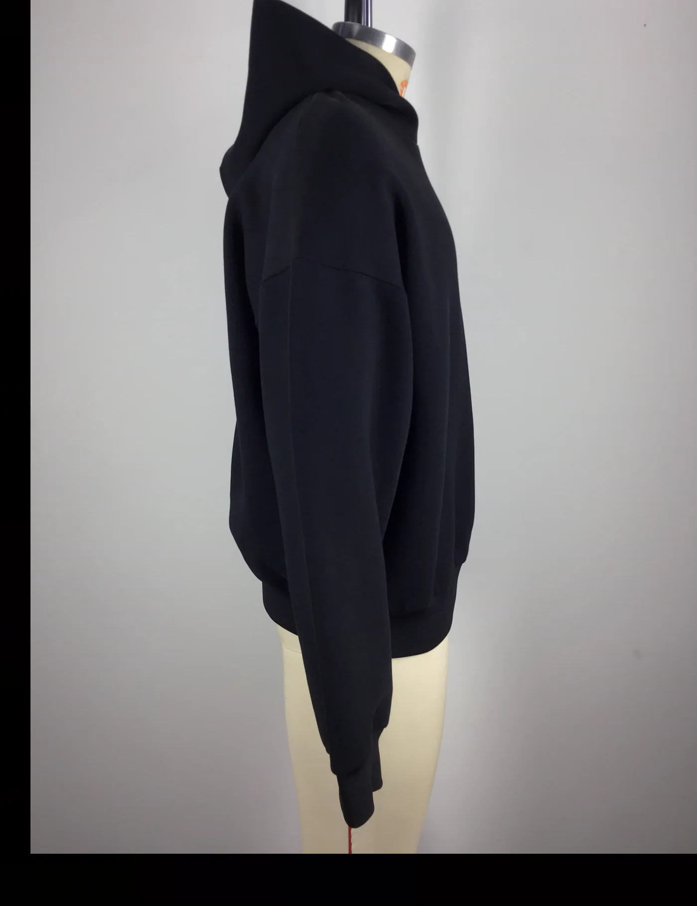 Actual black oversized pullover hoodie sample shown from the side on a mannequin