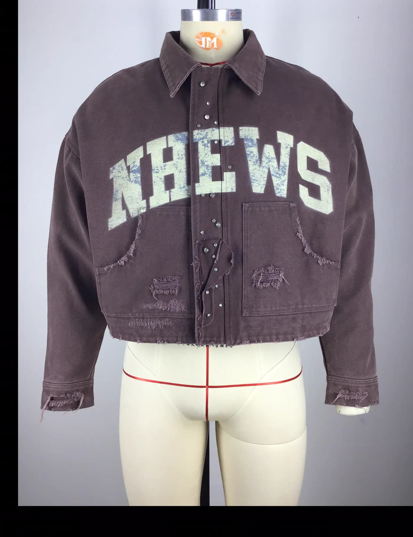 Actual brown cropped graphic workwear jacket sample shown from the front on a mannequin
