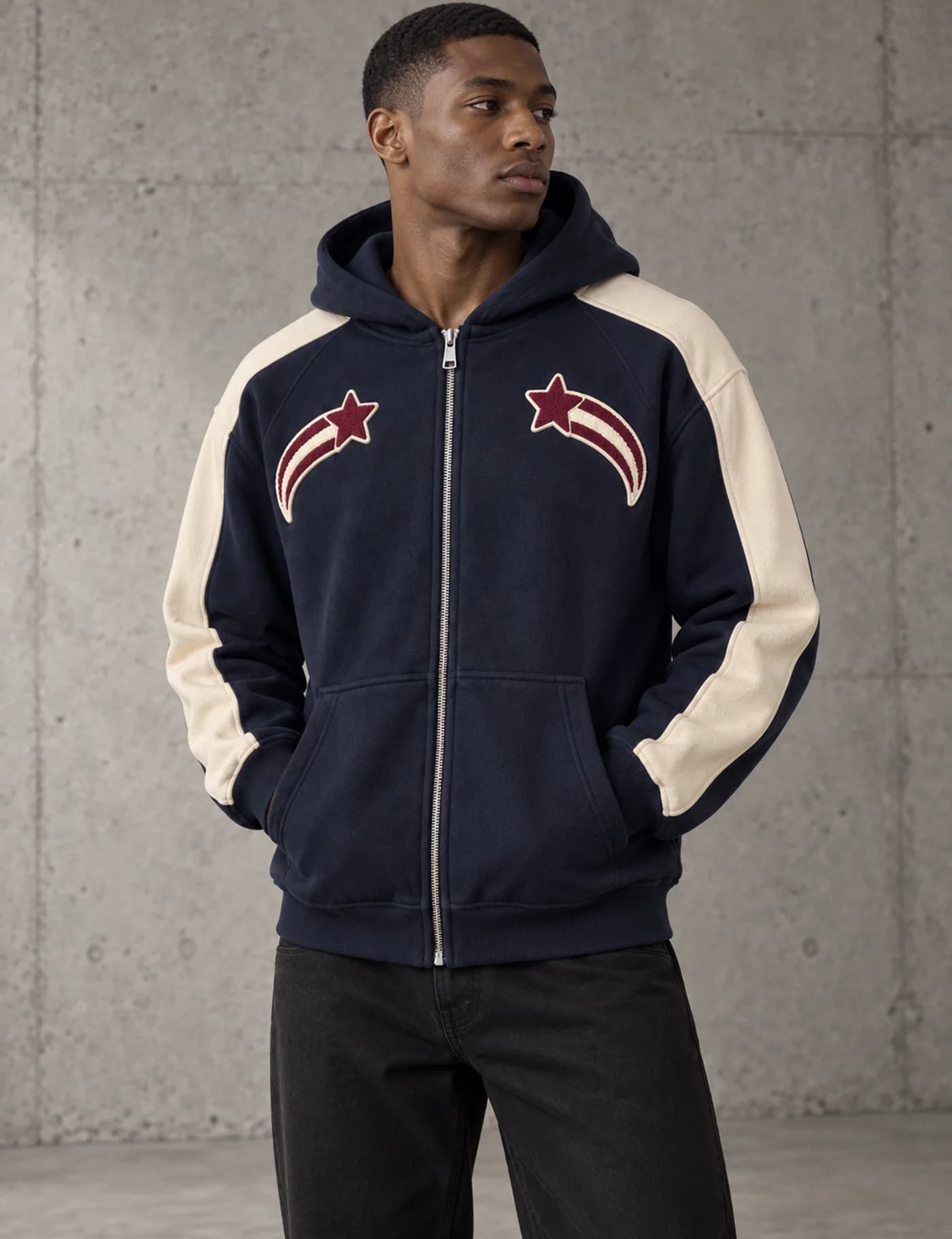 Male model wearing a navy and cream zip hoodie with chenille shooting-star patches