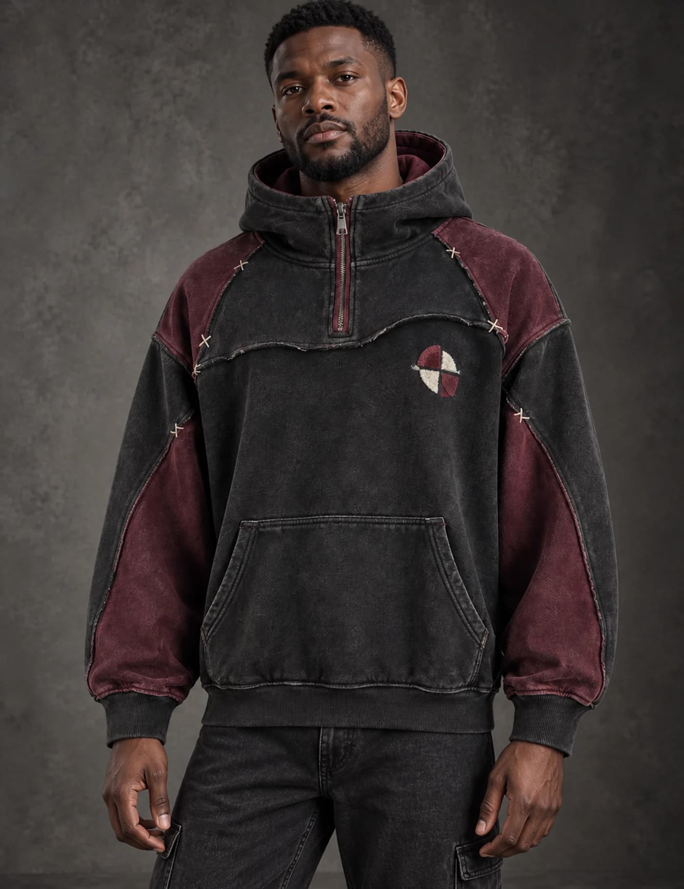 Black male model wearing a washed black and burgundy color-block quarter-zip hoodie