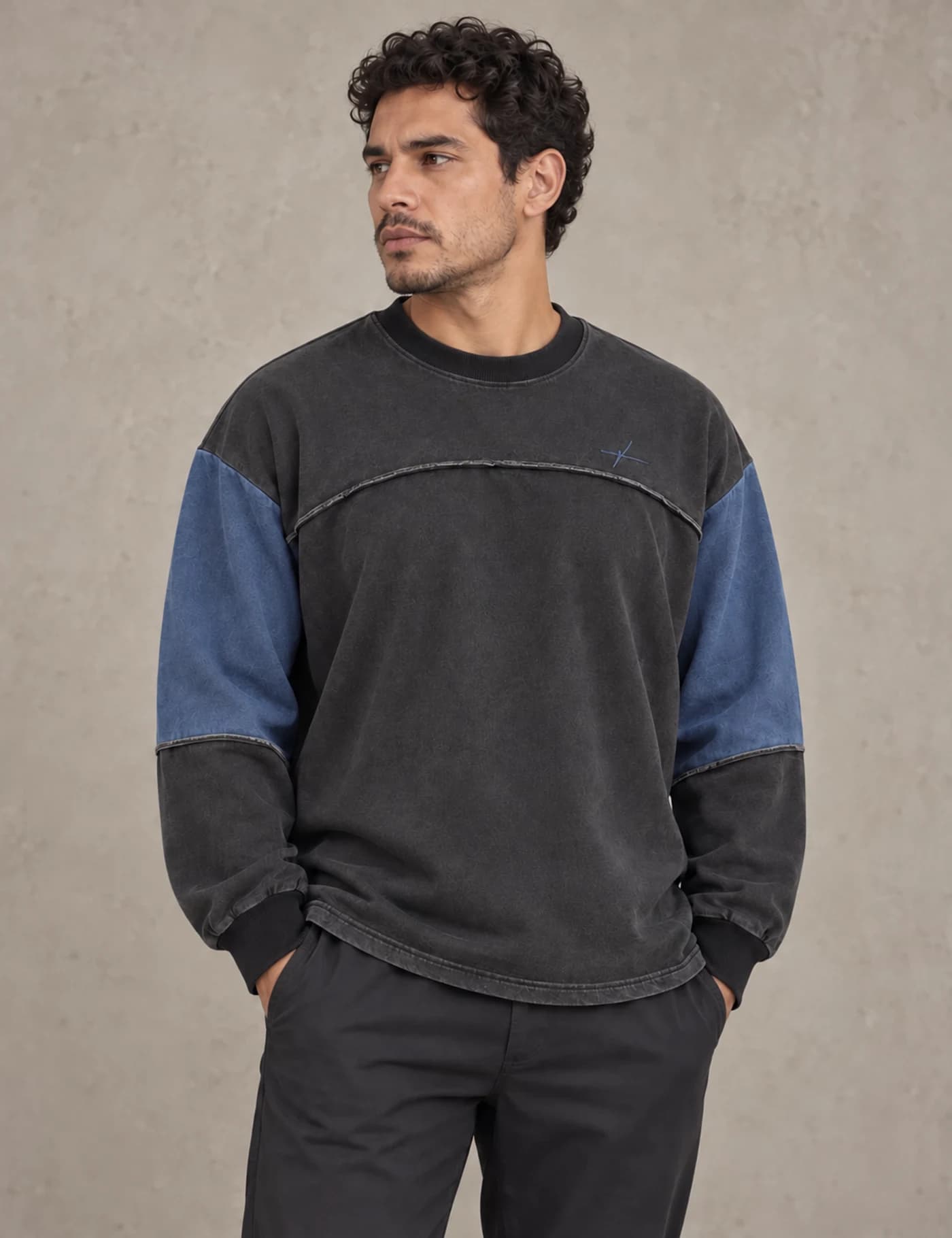 Latino male model wearing a charcoal and muted blue color-block yoke crewneck sweatshirt