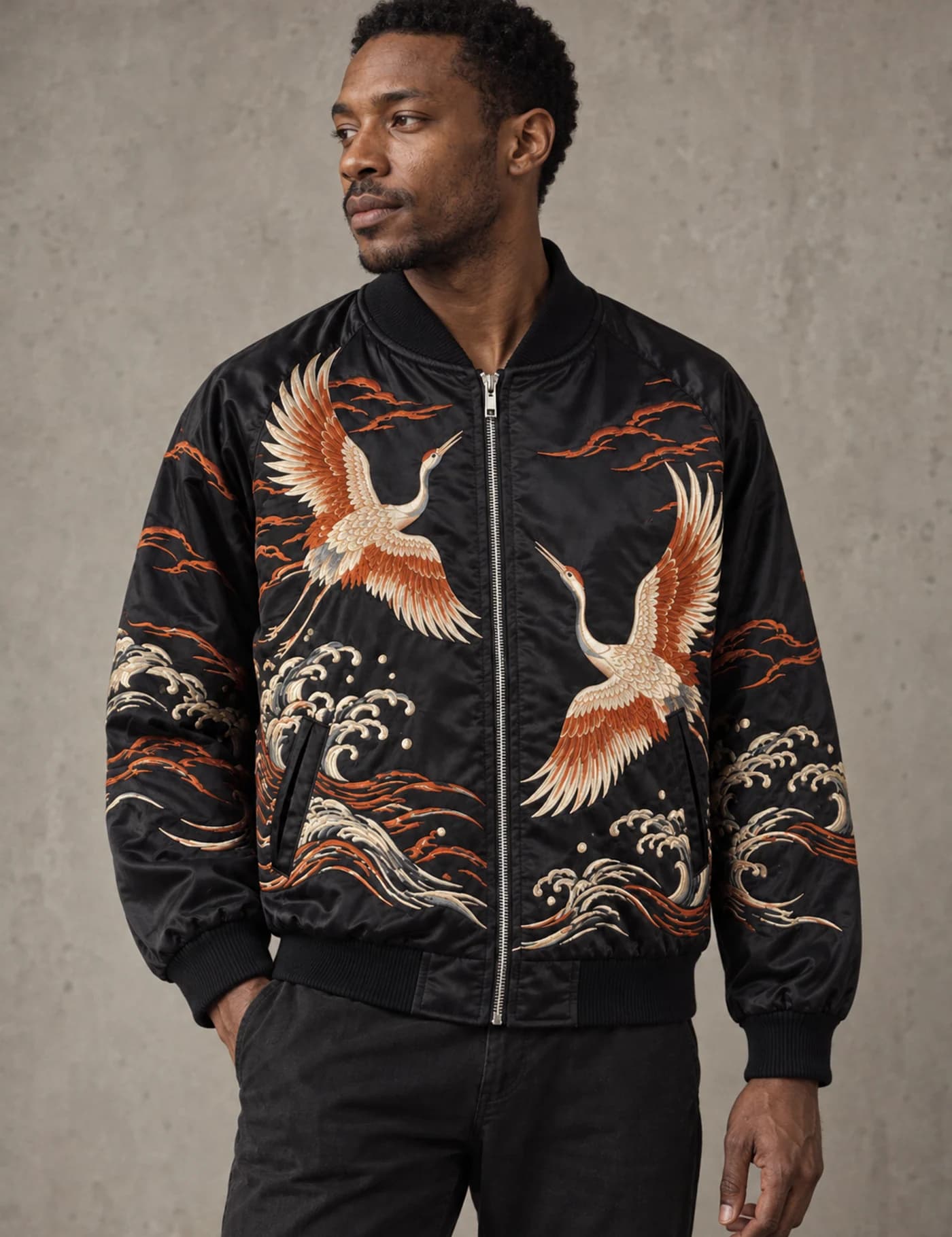 Male model wearing a black satin souvenir jacket with multicolor crane and wave embroidery