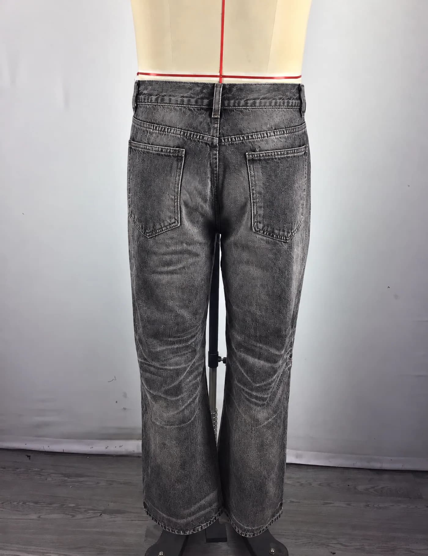 Actual distressed ripped straight-leg jeans sample shown from the back on a mannequin