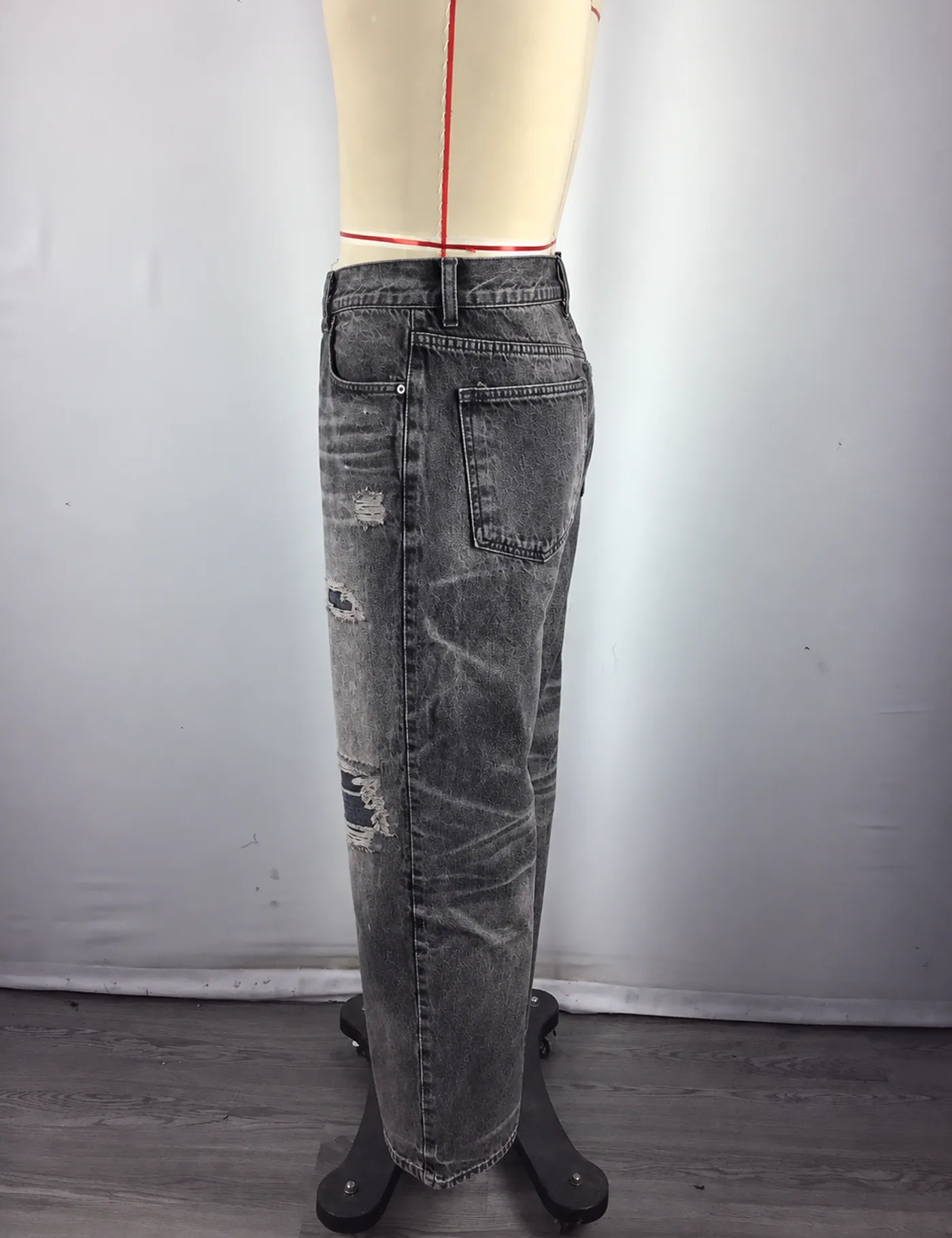 Actual distressed ripped straight-leg jeans sample shown from the side on a mannequin