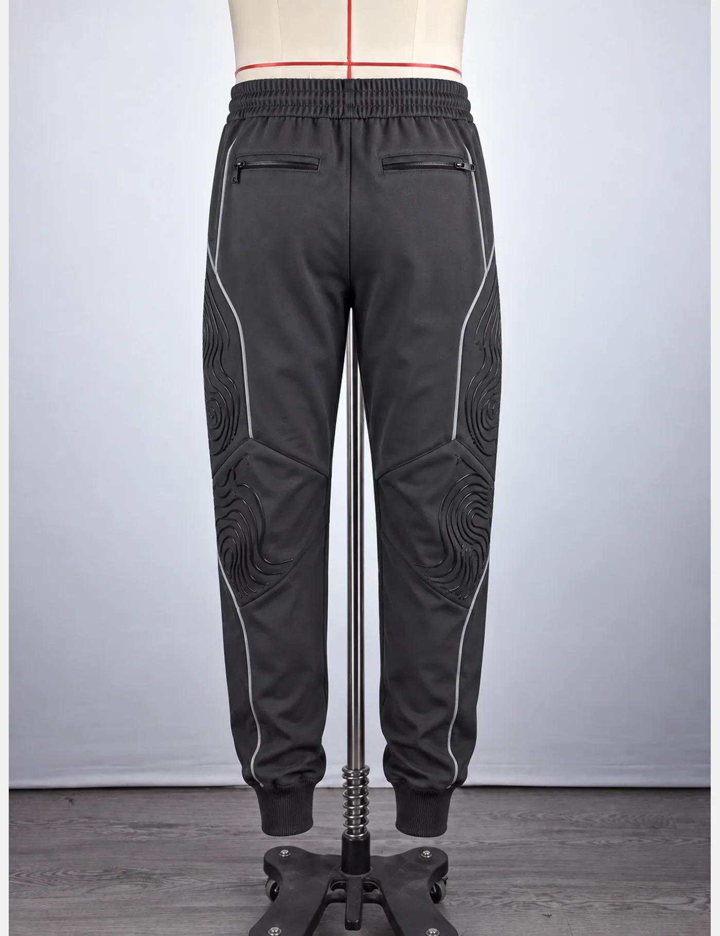 Actual embossed contour-knee technical joggers sample shown from the back on a mannequin