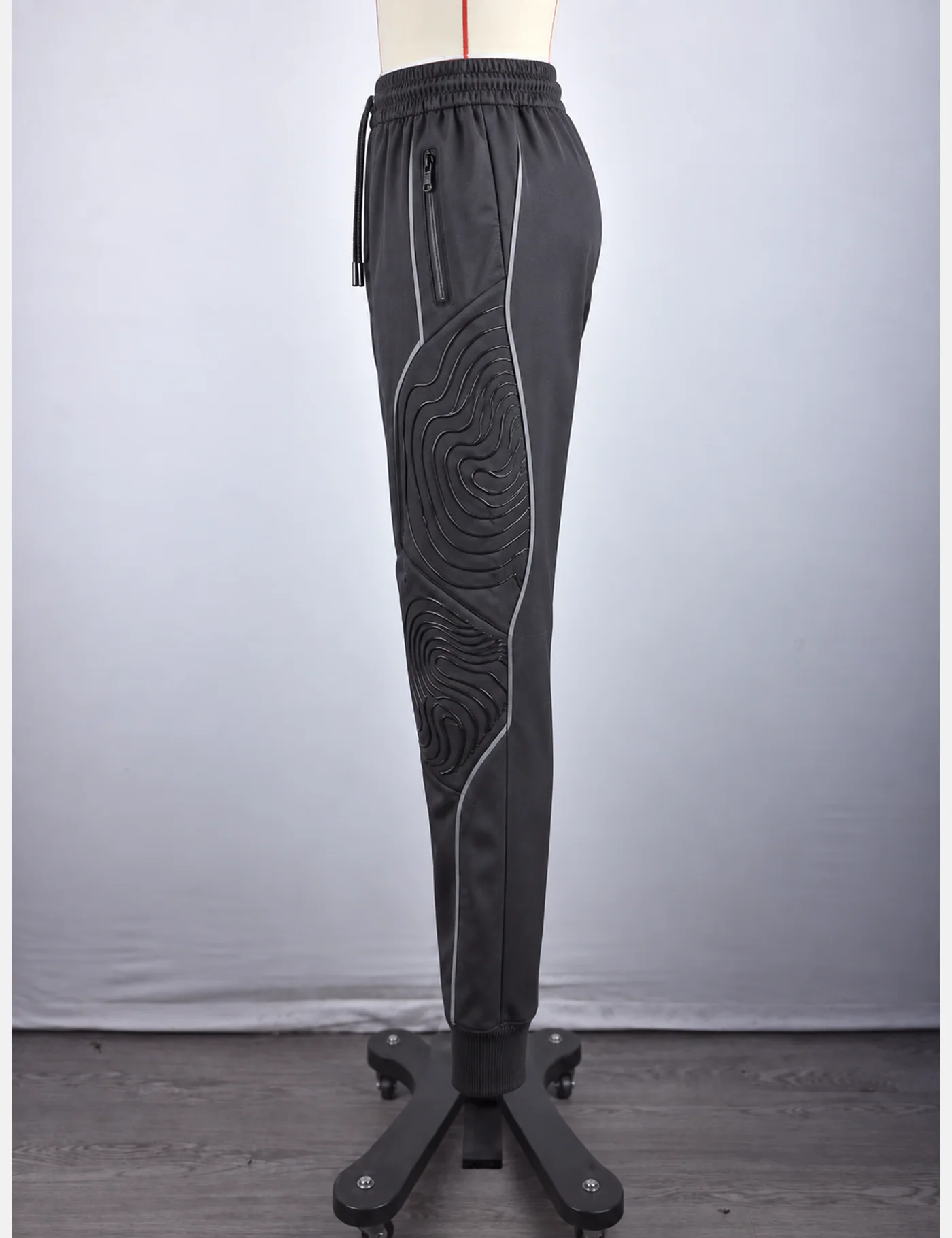 Actual embossed contour-knee technical joggers sample shown from the side on a mannequin