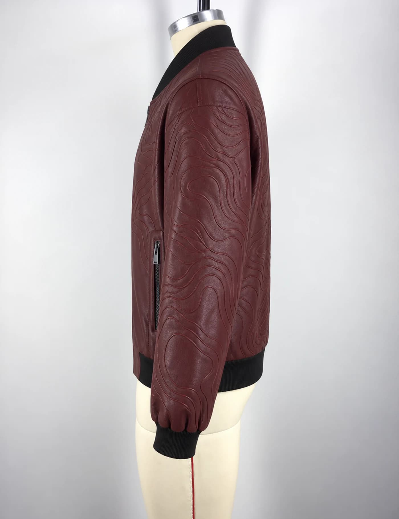 Actual embossed faux-leather bomber jacket sample shown from the side on a mannequin