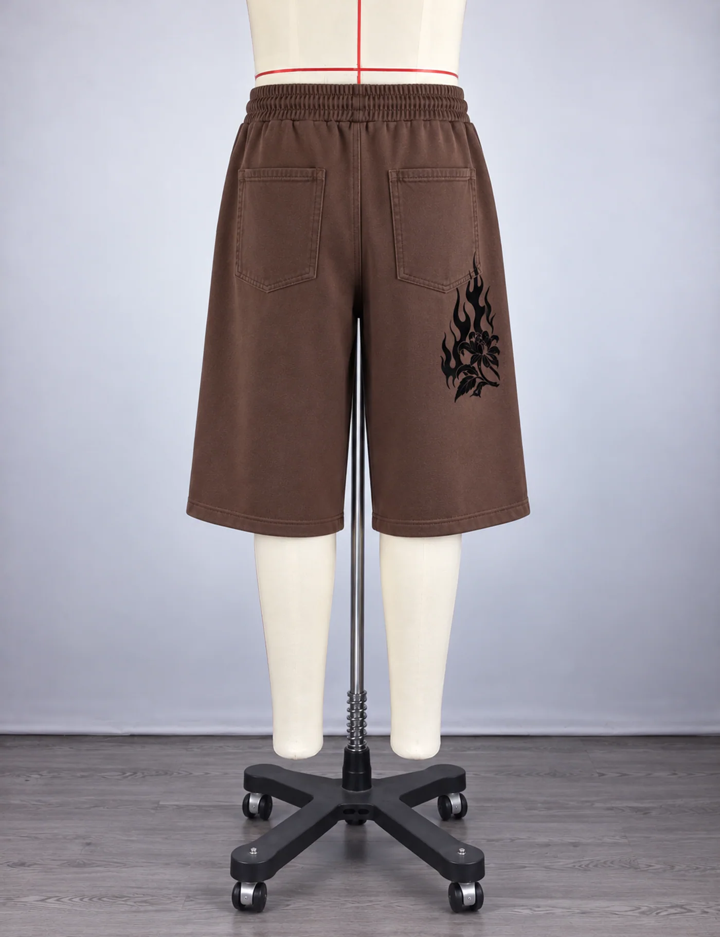 Actual flame graphic longline shorts sample shown from the back on a mannequin