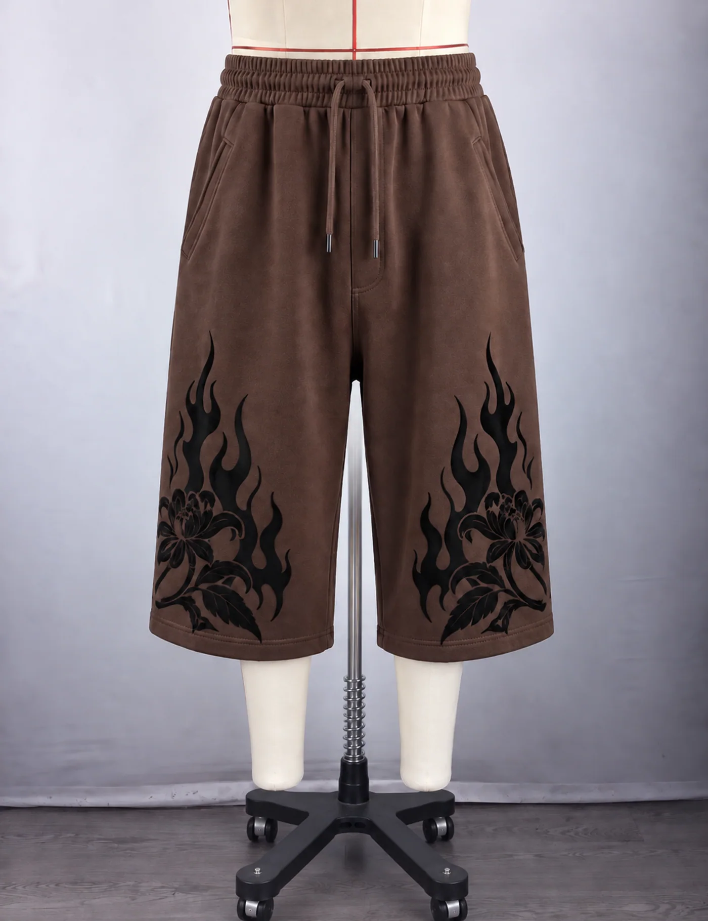 Actual flame graphic longline shorts sample shown from the front on a mannequin