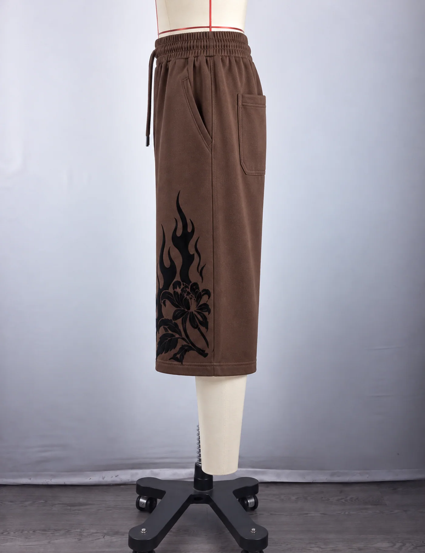 Actual flame graphic longline shorts sample shown from the side on a mannequin