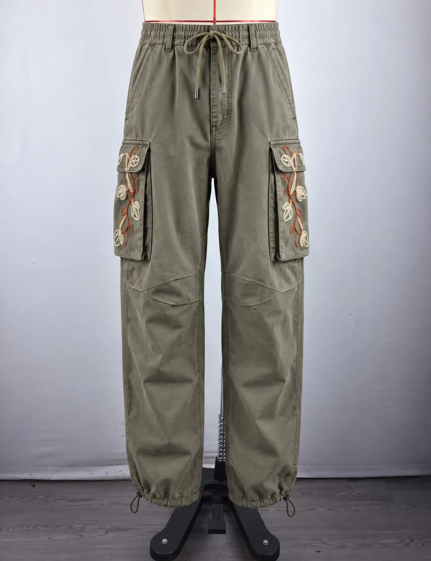 Actual floral embroidered cargo pants sample shown from the front on a mannequin