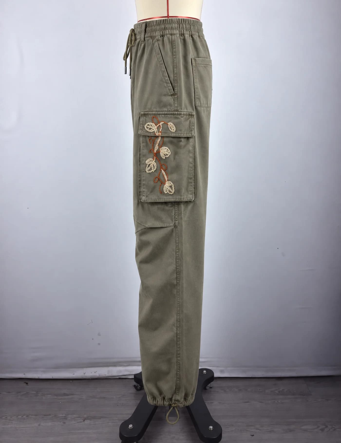 Actual floral embroidered cargo pants sample shown from the side on a mannequin