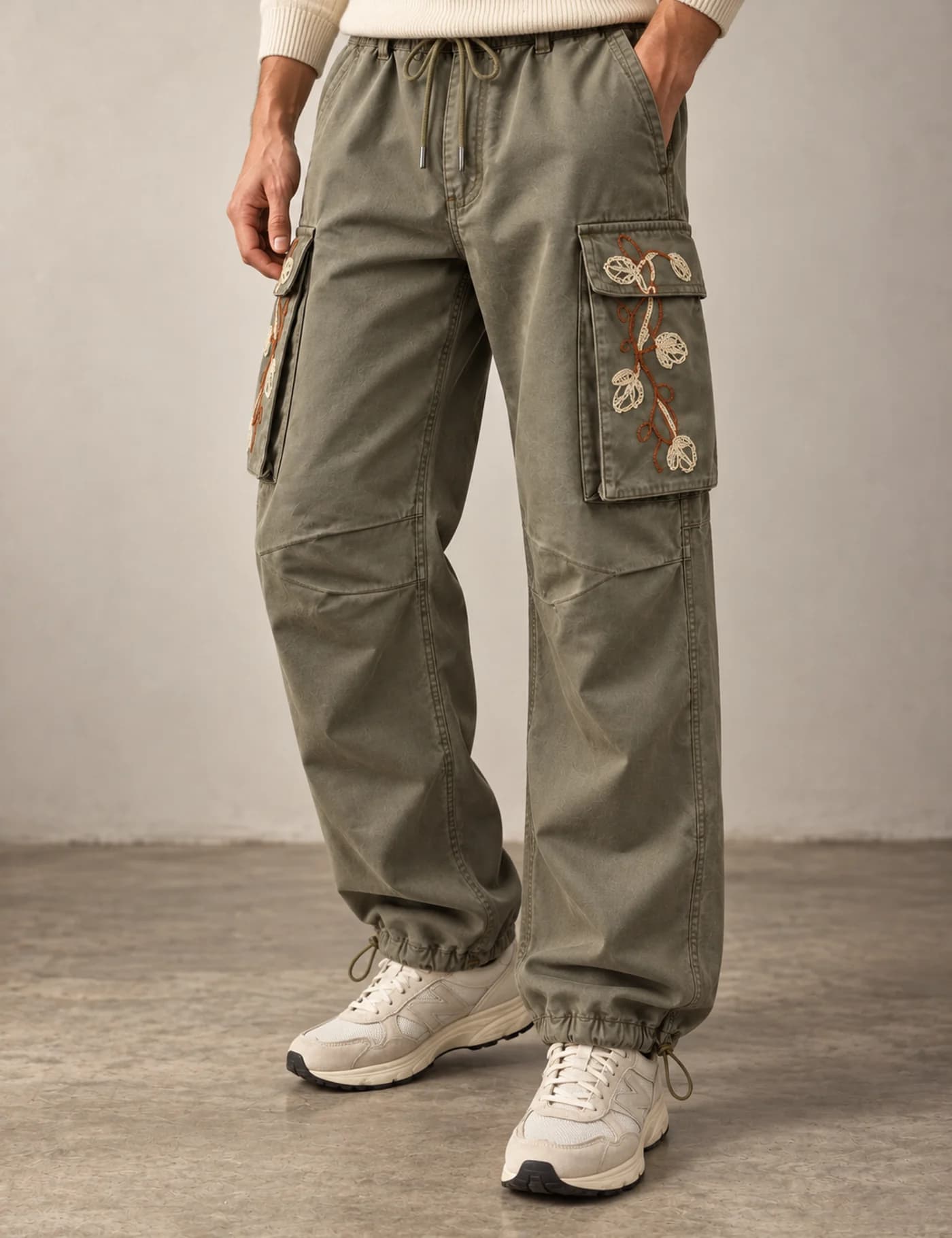 Lower-body view of a male model wearing washed olive floral embroidered cargo pants