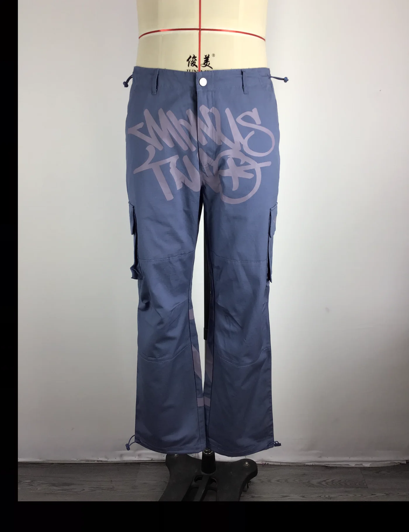 Actual graphic wide-leg cargo pants sample shown from the front on a mannequin