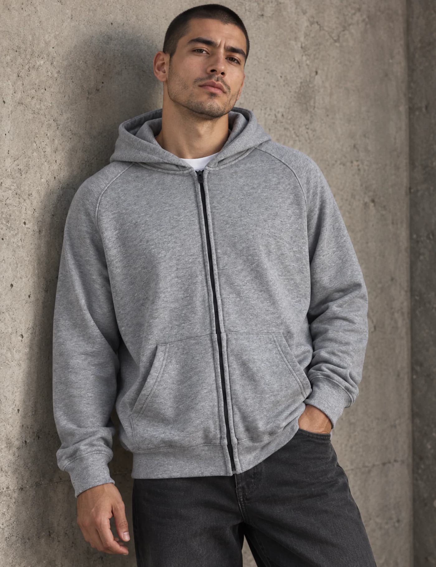 Male model wearing a clean heather-gray full-zip hoodie with raglan-style seams and split pockets