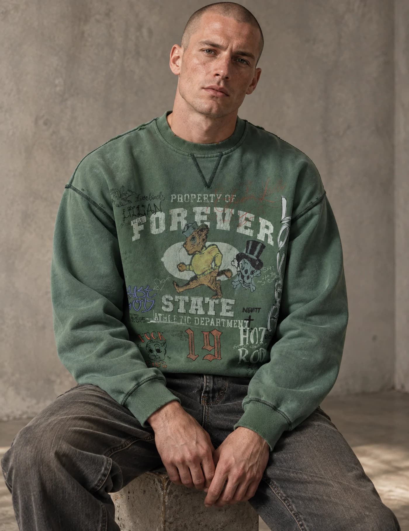 Male model wearing a green vintage-washed graphic crewneck sweatshirt with exposed seam details