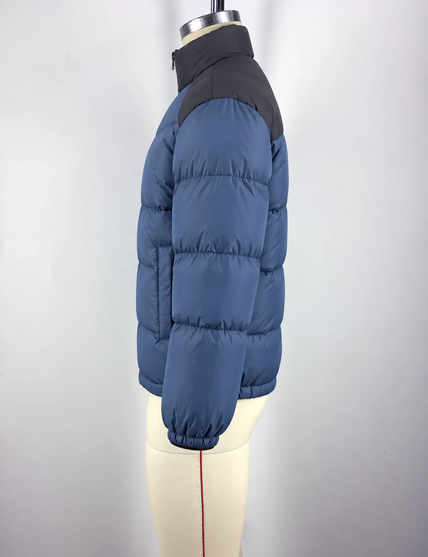 Actual lightweight color-block puffer jacket sample shown from the side on a mannequin