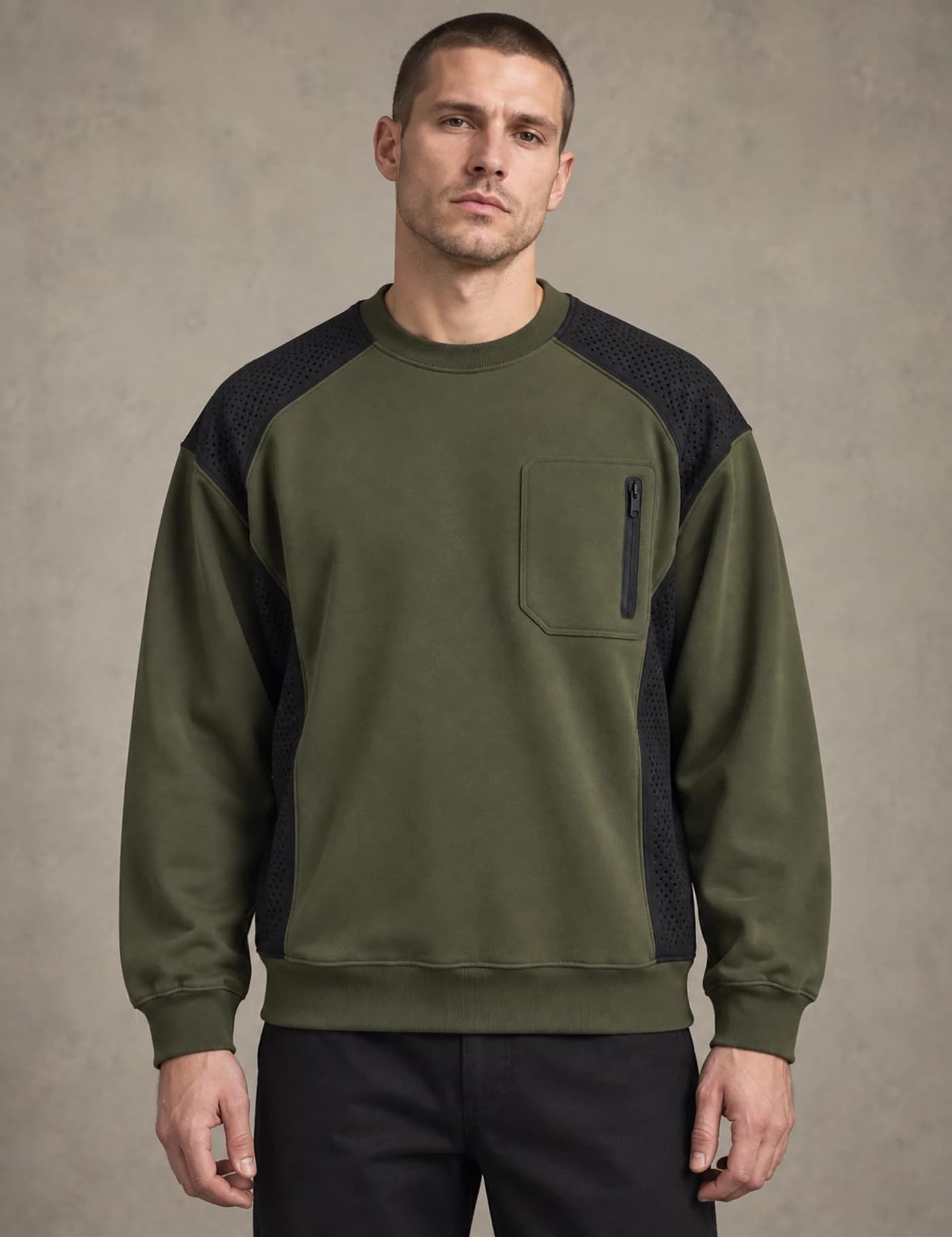 Male model wearing an olive utility crewneck sweatshirt with black perforated shoulder panels