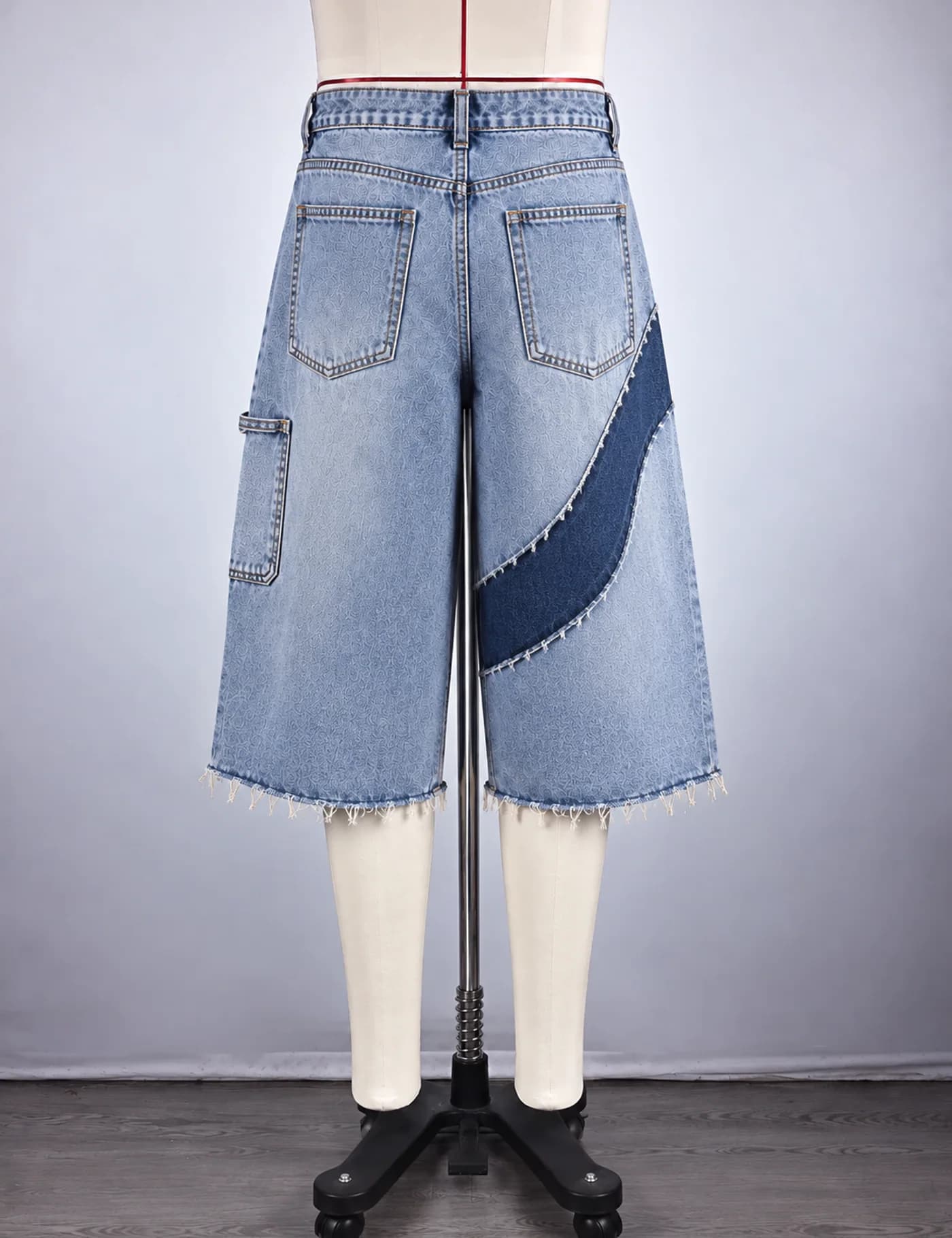 Actual raw-edge appliqué denim jorts sample shown from the back on a mannequin