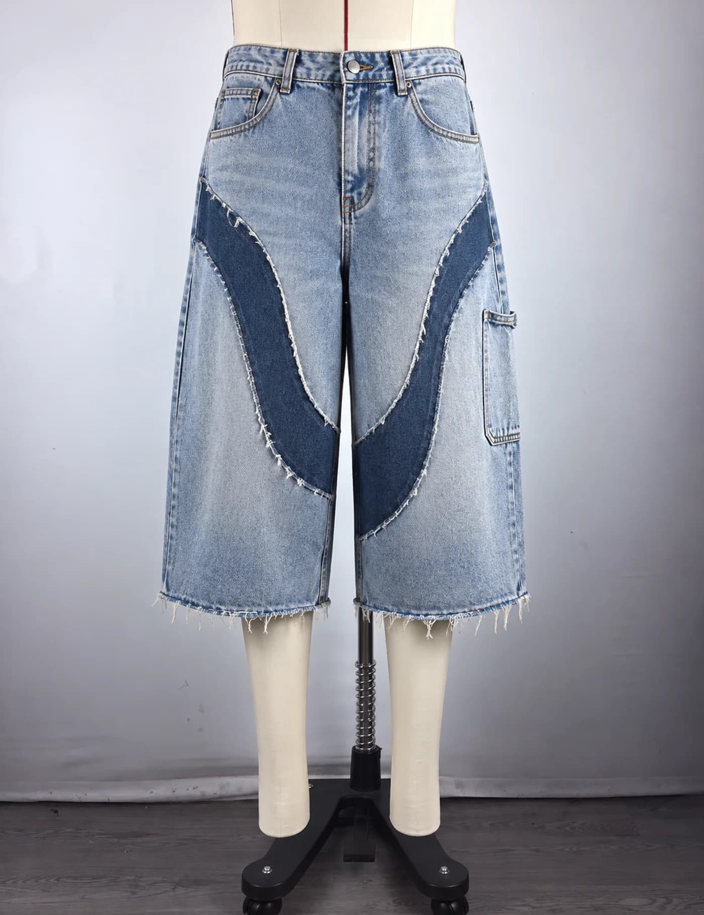Actual raw-edge appliqué denim jorts sample shown from the front on a mannequin