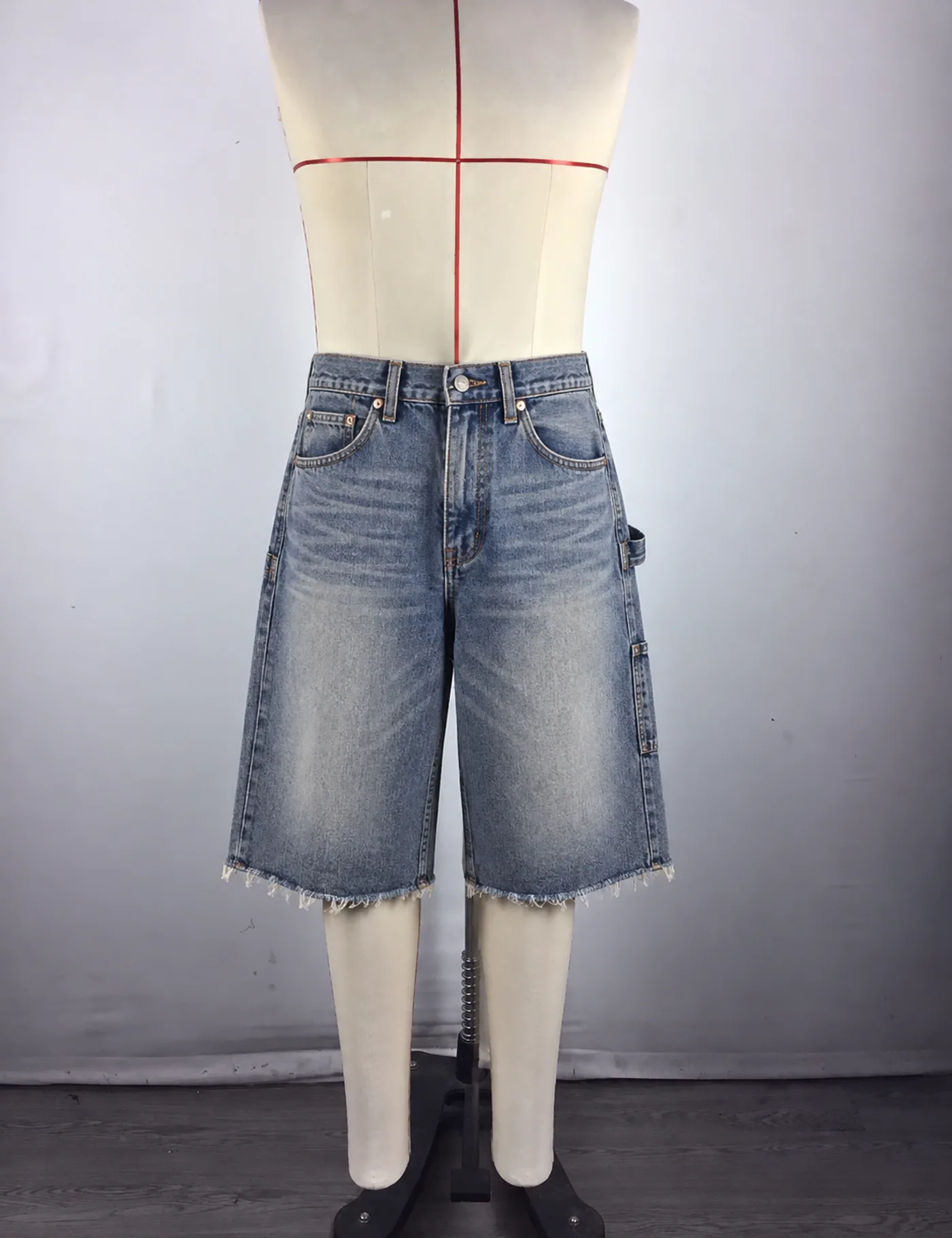 Actual raw-hem carpenter denim jorts sample shown from the front on a mannequin