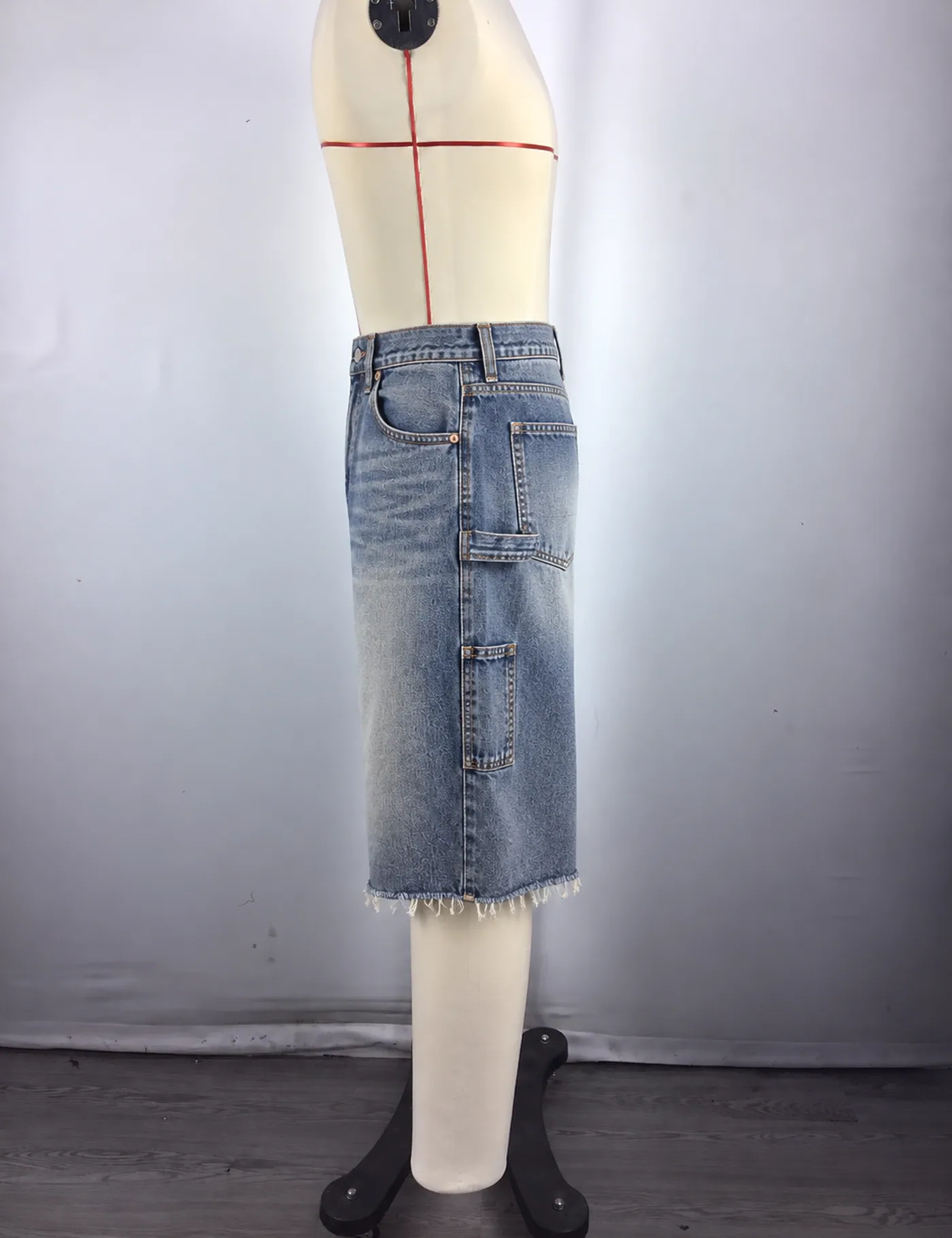 Actual raw-hem carpenter denim jorts sample shown from the side on a mannequin