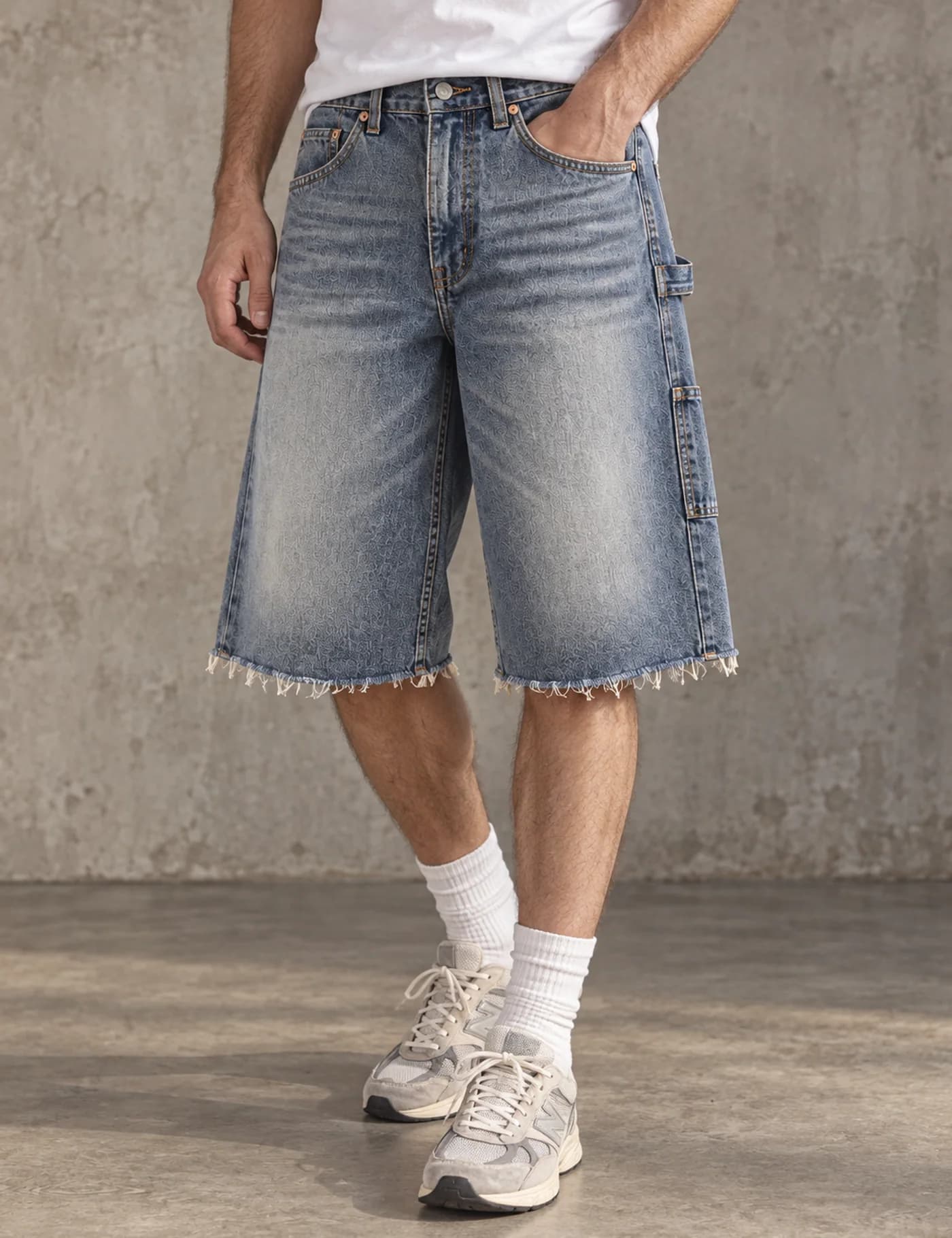 Male lower-body model wearing light blue washed carpenter denim jorts with raw hems