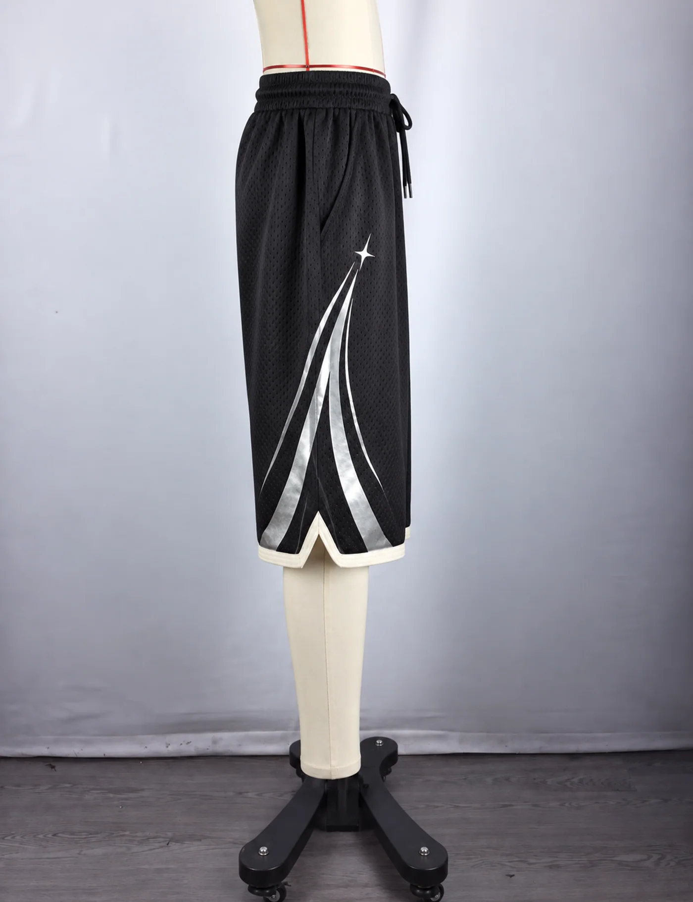 Actual reflective arc mesh basketball shorts sample shown from the side on a mannequin