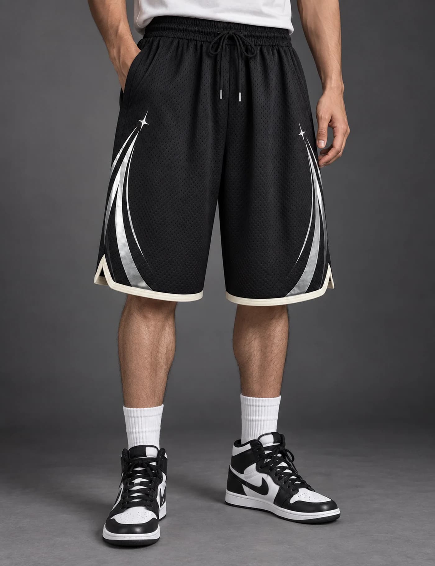 Male model wearing black mesh basketball shorts with silver reflective arc graphics