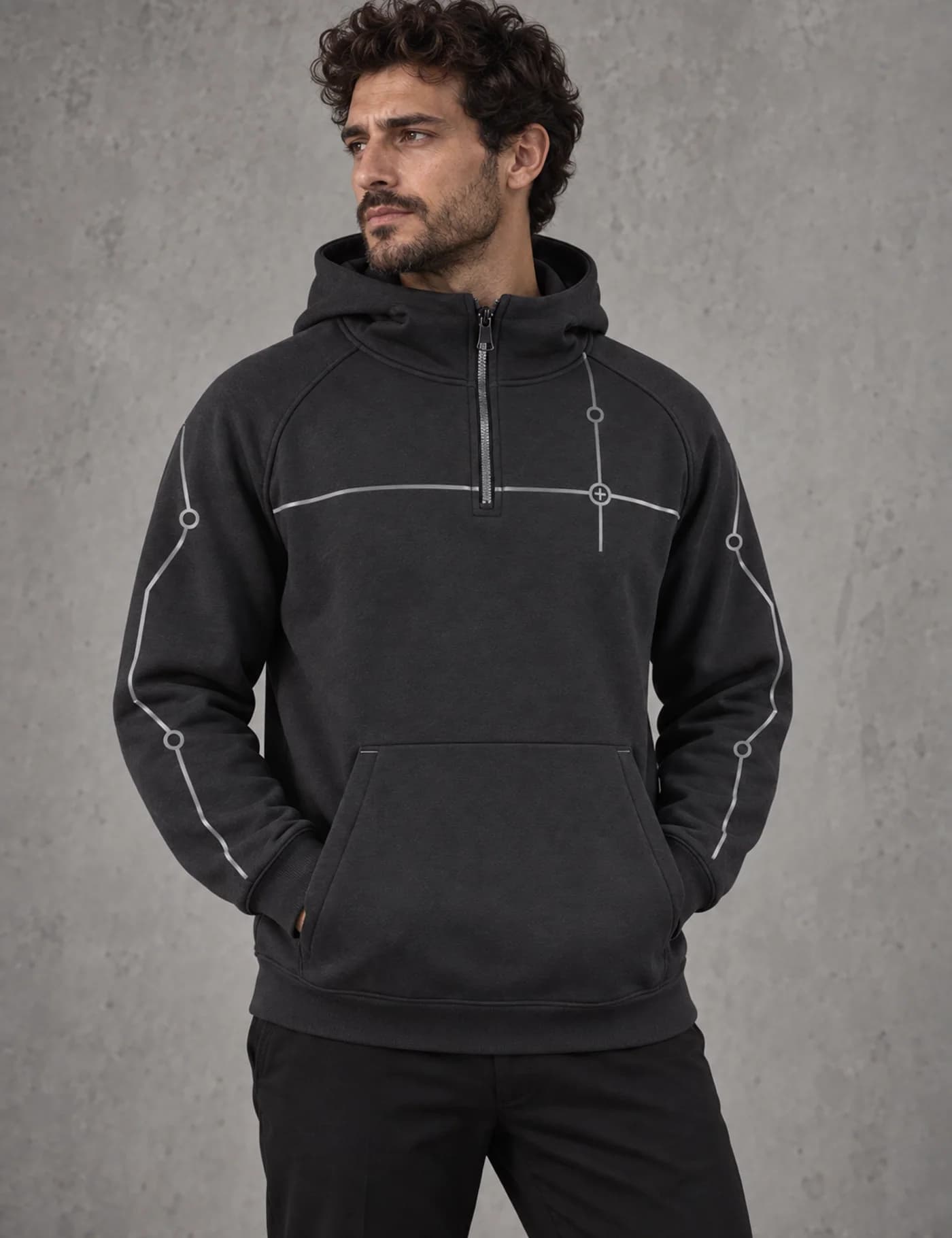 Male model wearing a charcoal half-zip hoodie with reflective circuit-style piping