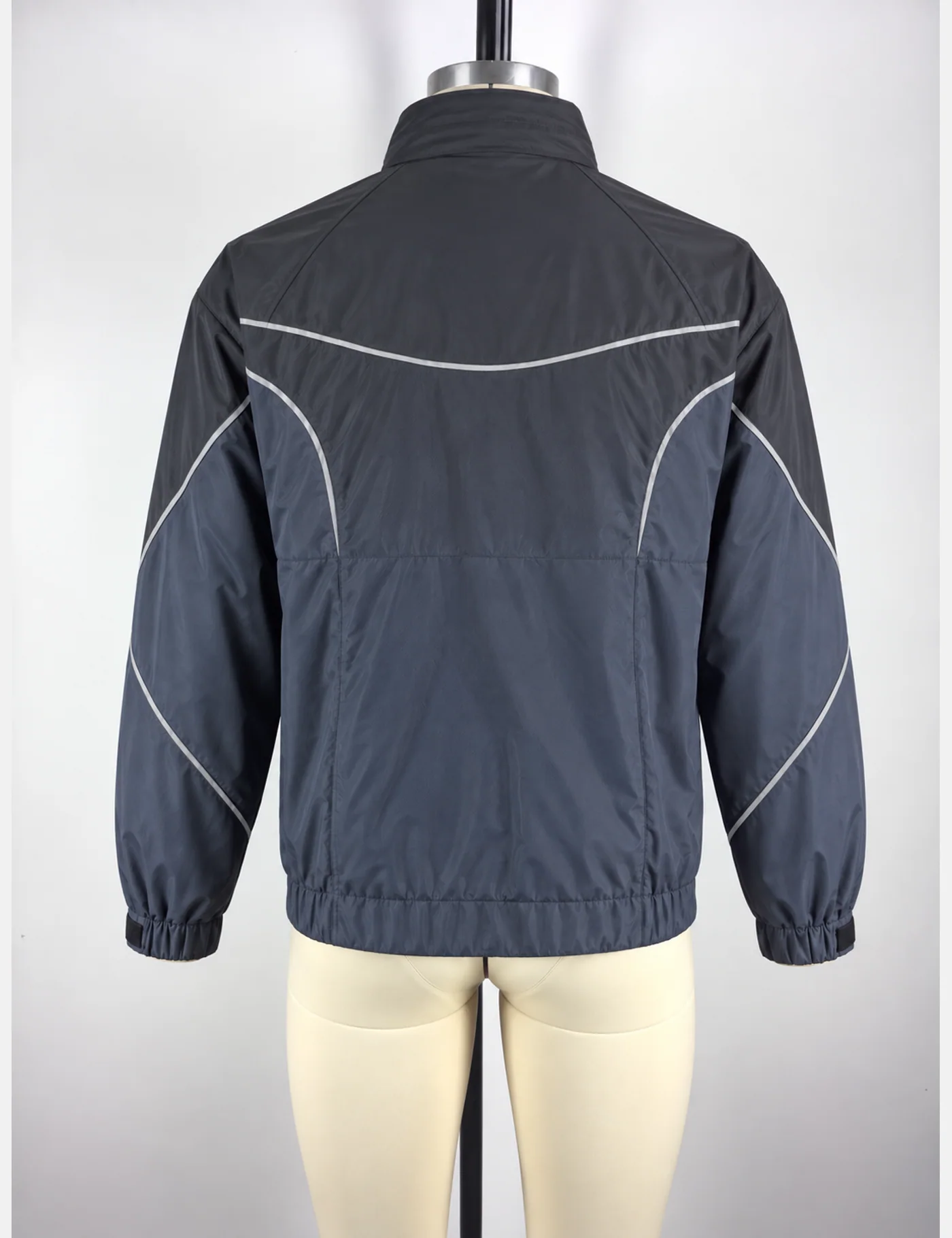 Actual reflective curved-panel windbreaker jacket sample shown from the back on a mannequin