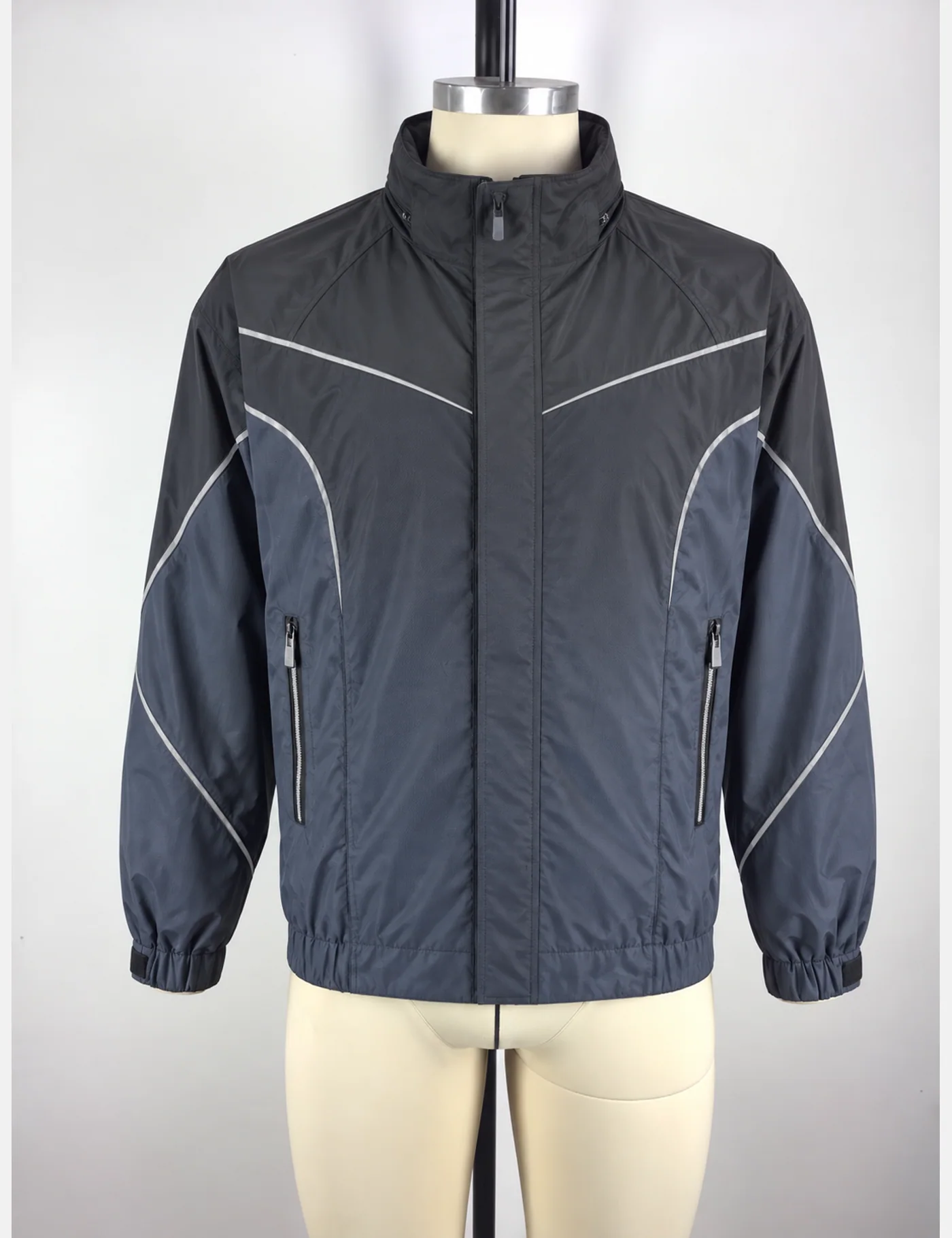 Actual reflective curved-panel windbreaker jacket sample shown from the front on a mannequin