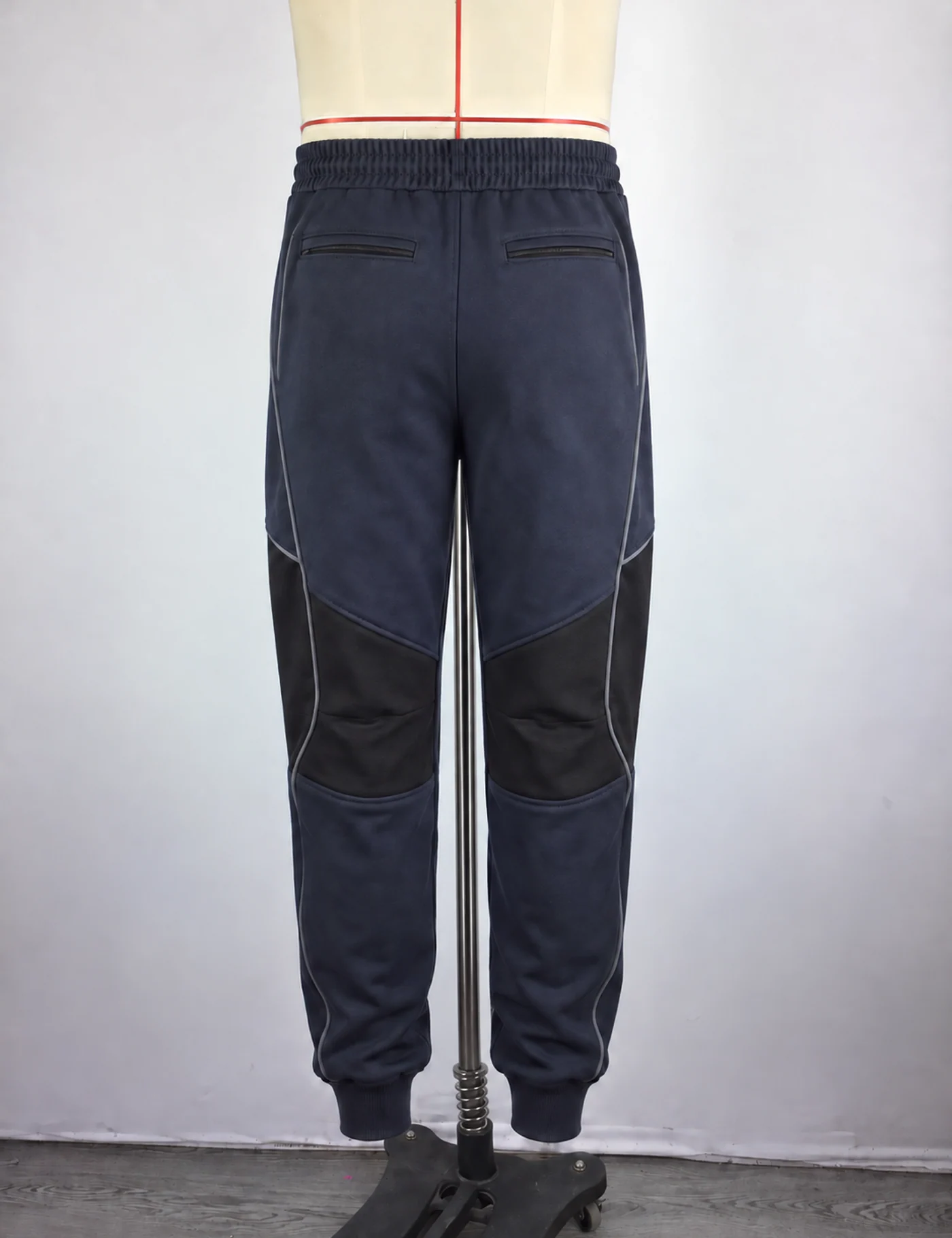 Actual reflective-panel technical joggers sample shown from the back on a mannequin