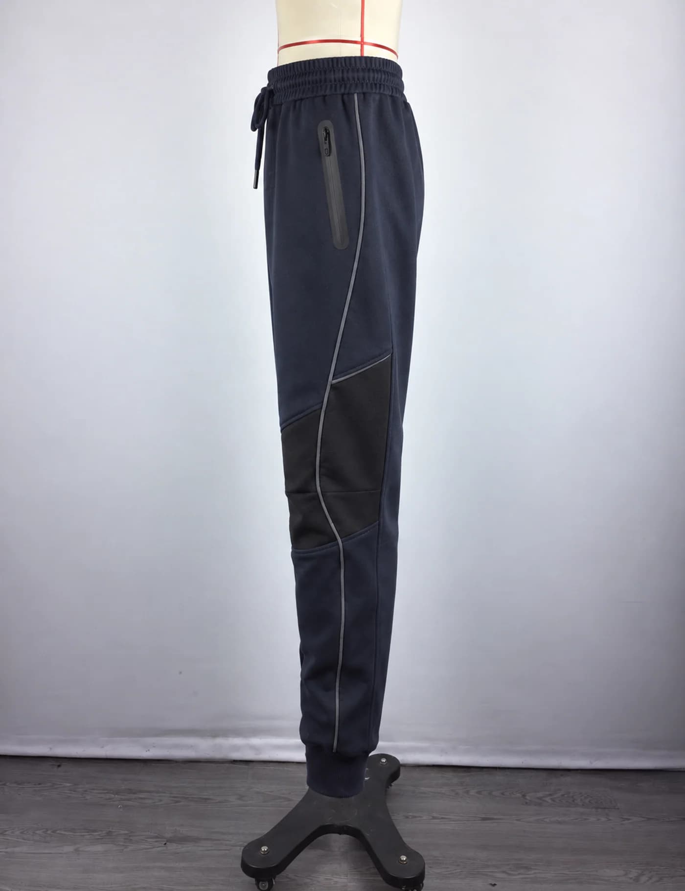 Actual reflective-panel technical joggers sample shown from the side on a mannequin