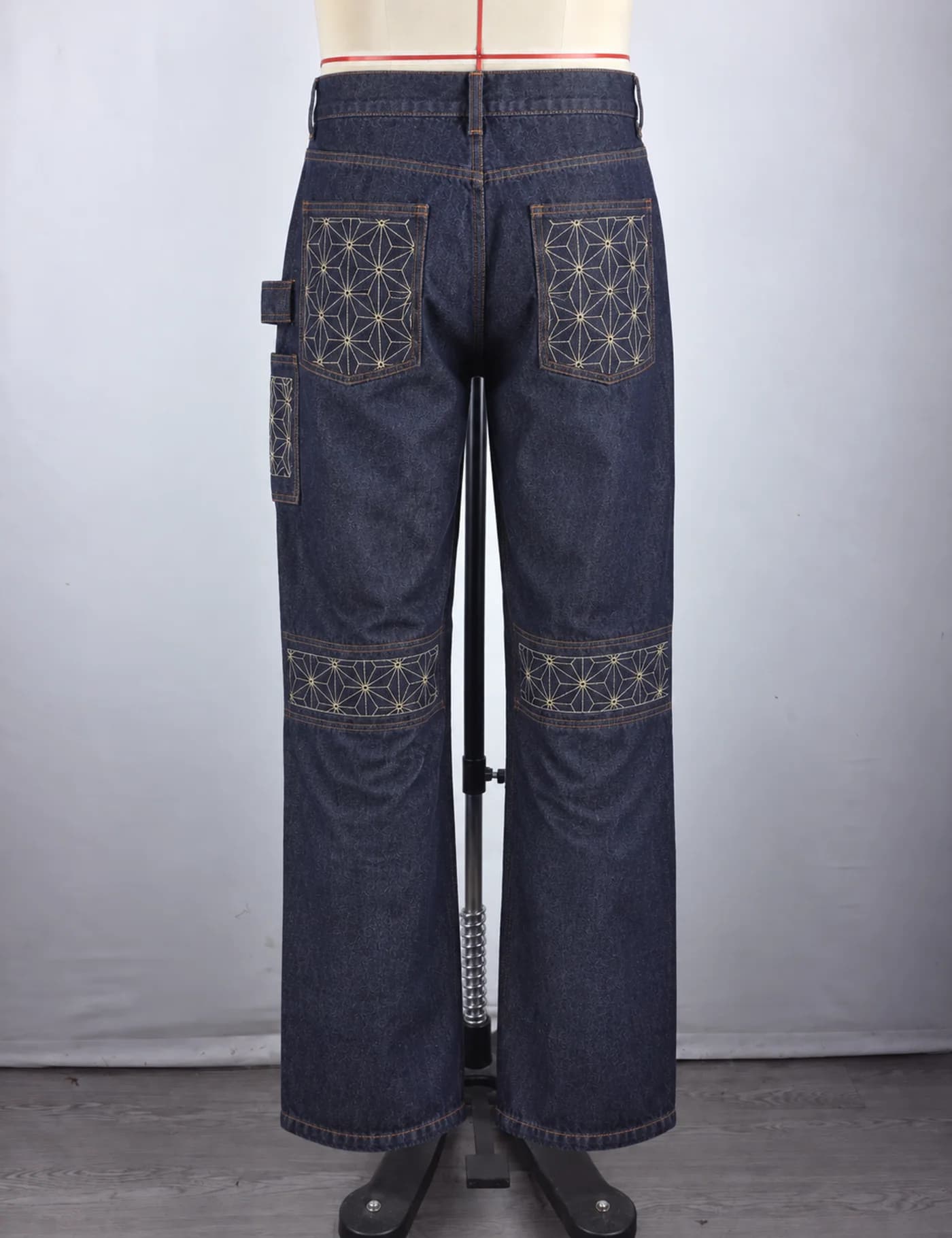 Actual sashiko knee-panel utility jeans sample shown from the back on a mannequin