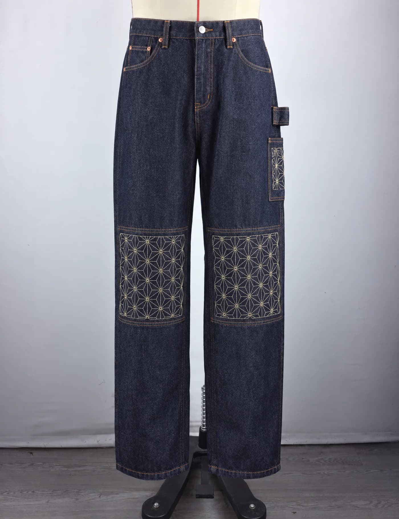 Actual sashiko knee-panel utility jeans sample shown from the front on a mannequin