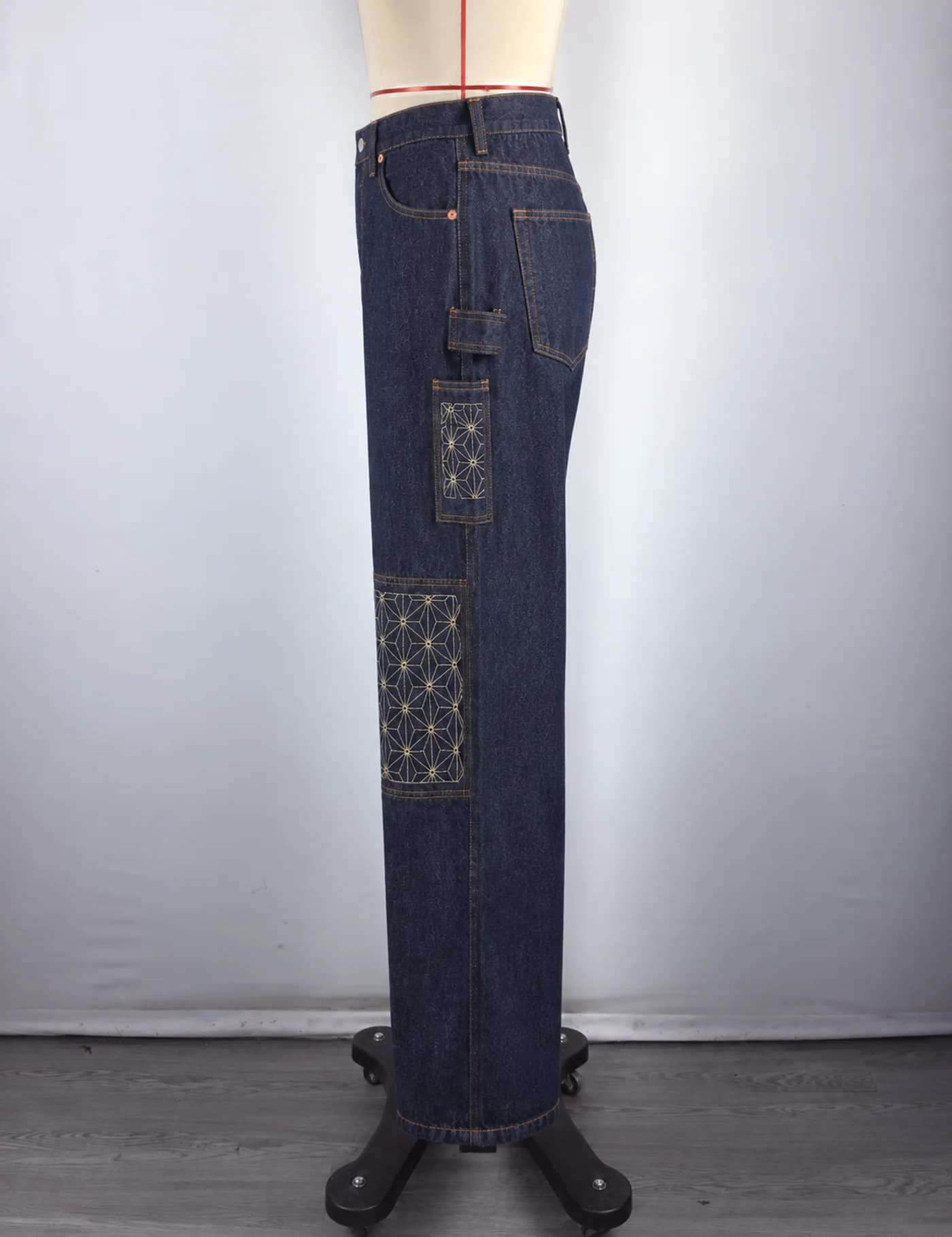 Actual sashiko knee-panel utility jeans sample shown from the side on a mannequin