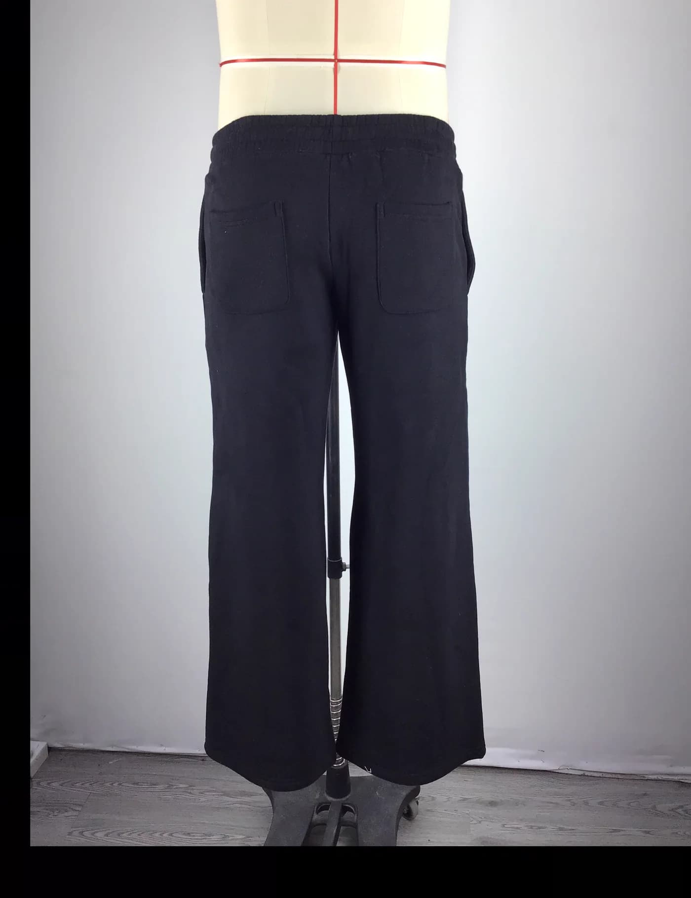 Actual striped wide-leg track pants sample shown from the back on a mannequin