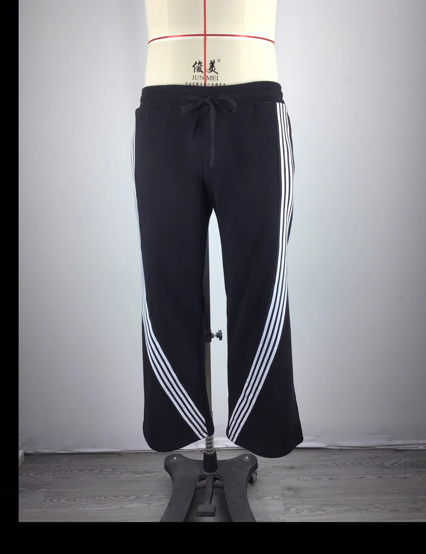 Actual striped wide-leg track pants sample shown from the front on a mannequin