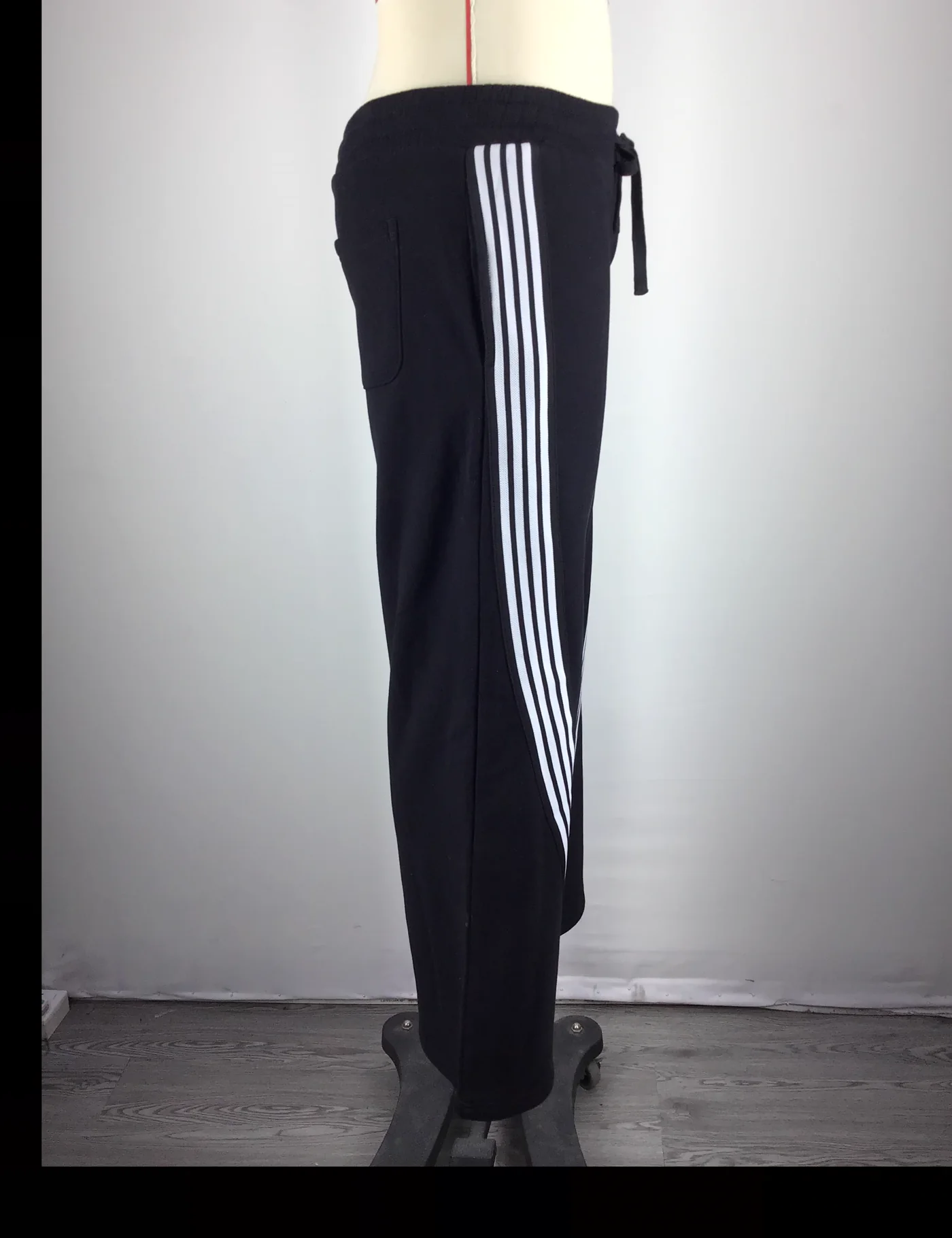 Actual striped wide-leg track pants sample shown from the side on a mannequin
