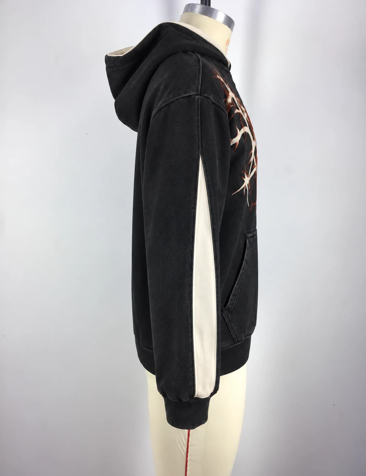 Actual thorn embroidered oversized hoodie sample shown from the side on a mannequin