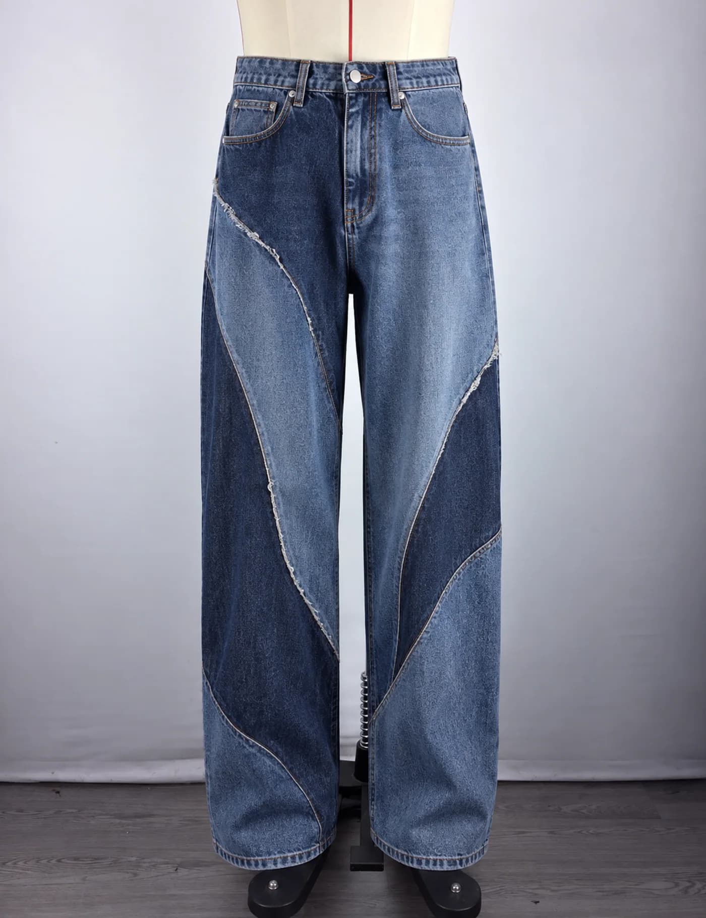 Actual two-tone curved-panel wide-leg jeans sample shown from the front on a mannequin