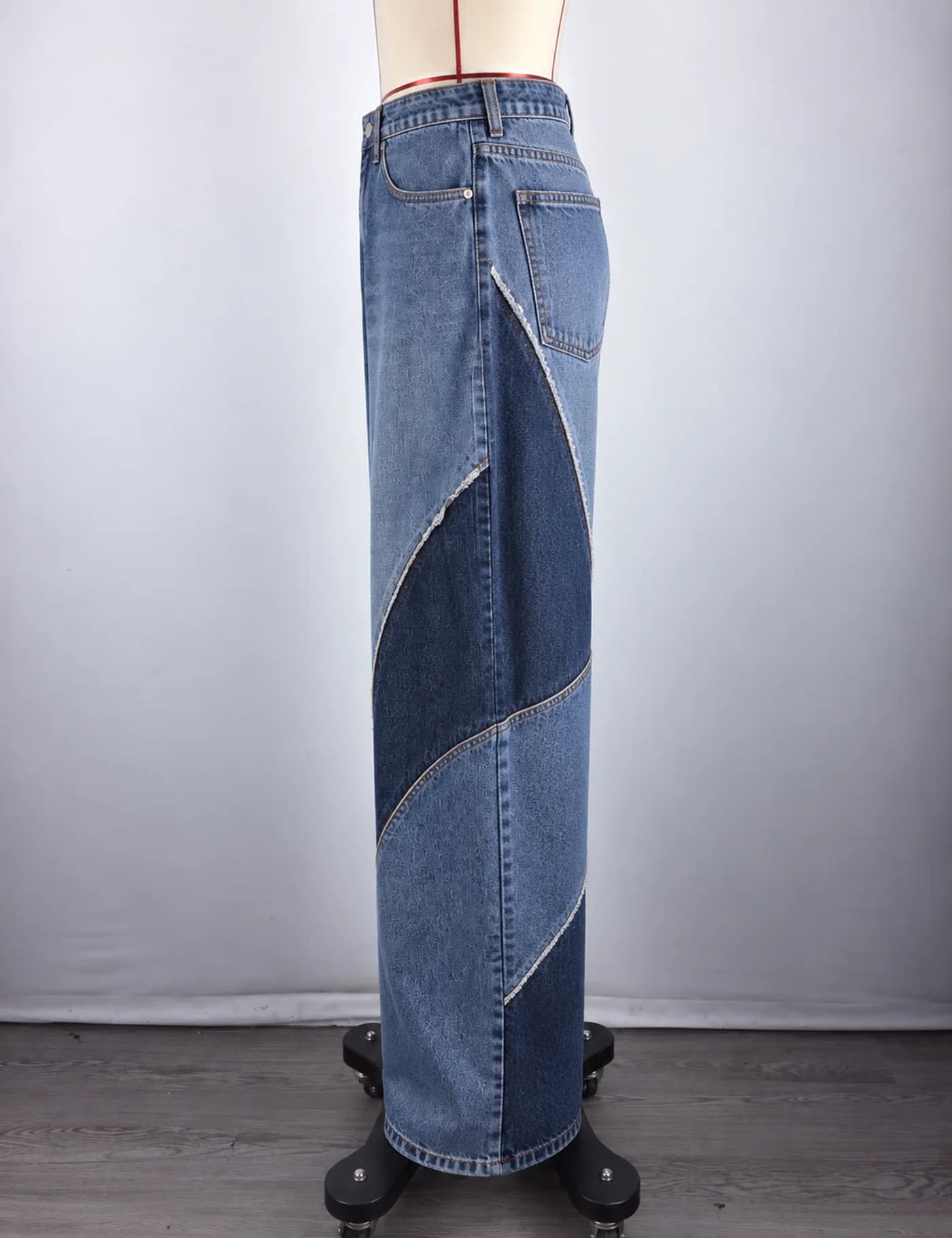 Actual two-tone curved-panel wide-leg jeans sample shown from the side on a mannequin